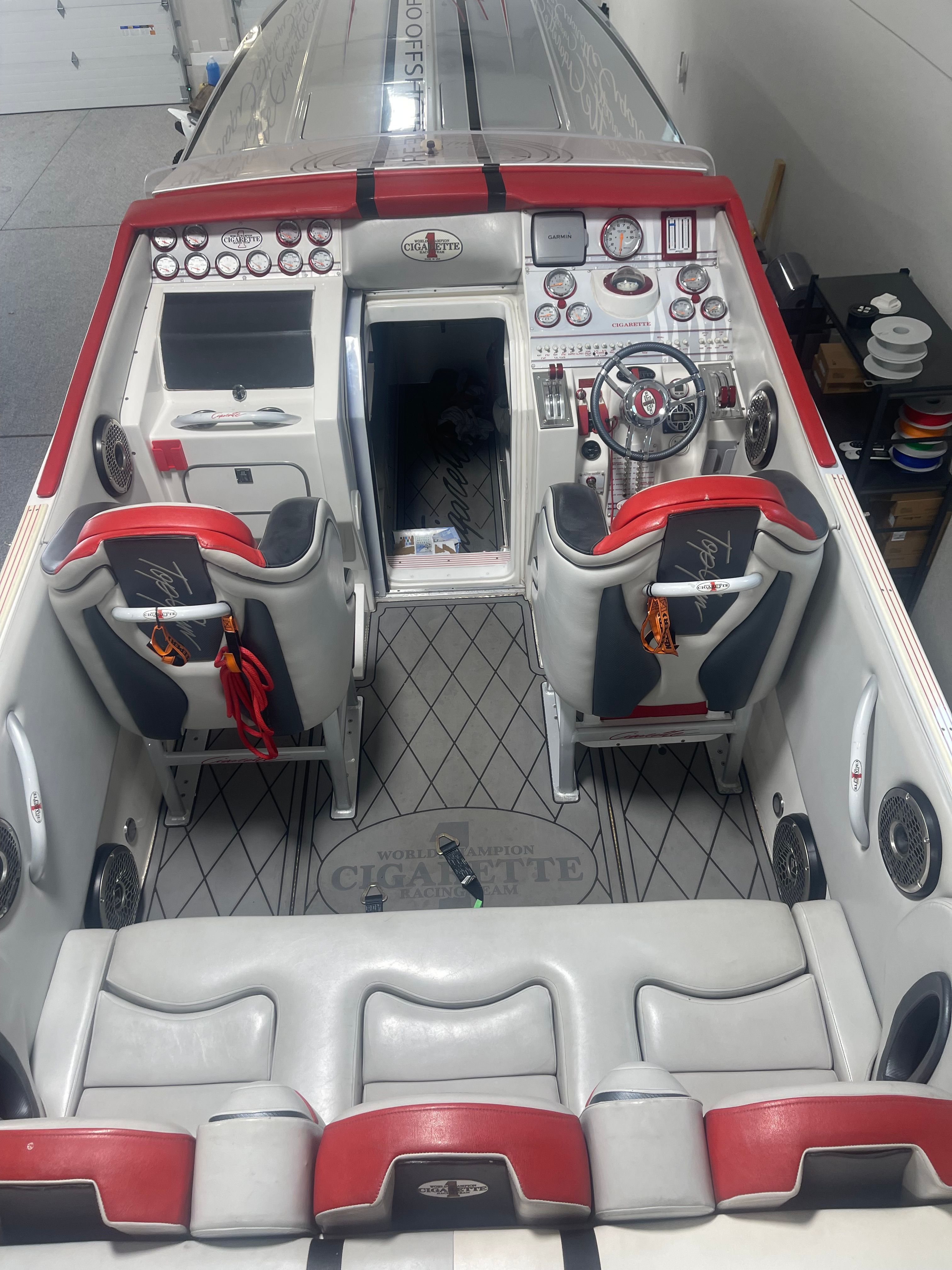 Interior of a 2004 Cigarette 38' Top Gun boat with red and gray seating.