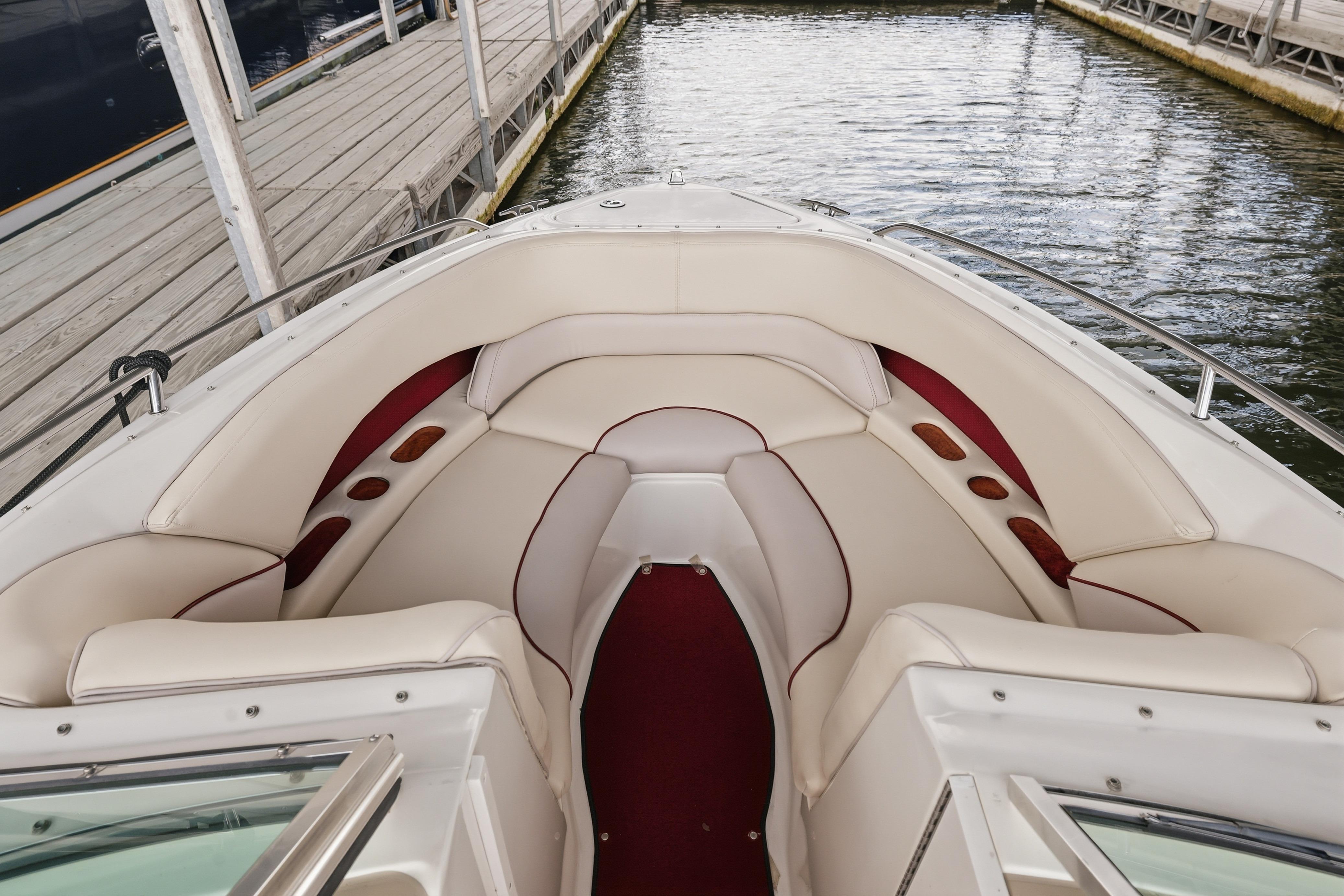 1997 Sea Ray 230 Signature boat interior with white and red seating at dock.