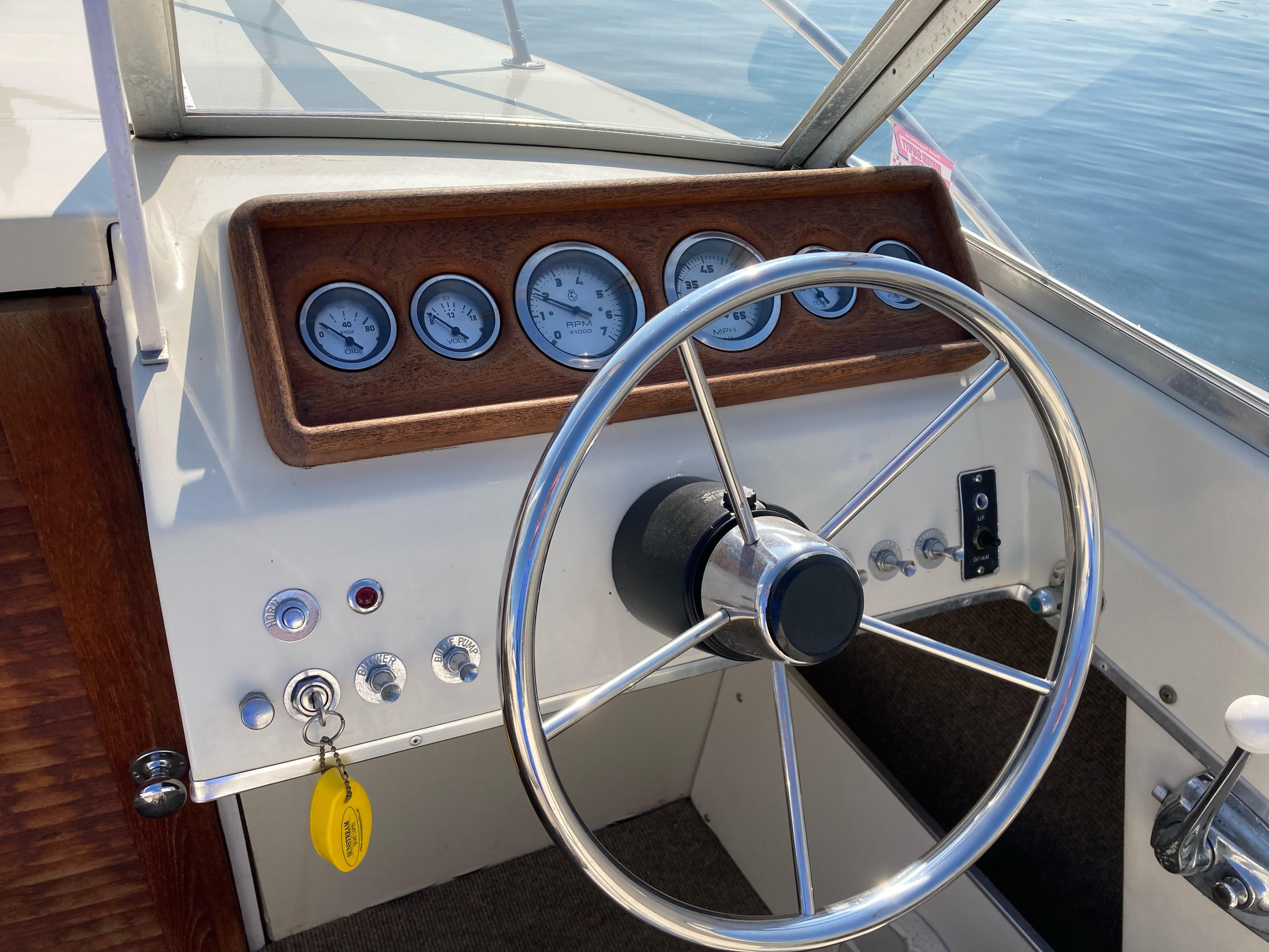 1970 Chris-Craft Lancer 23 boat dashboard with steering wheel and gauges.