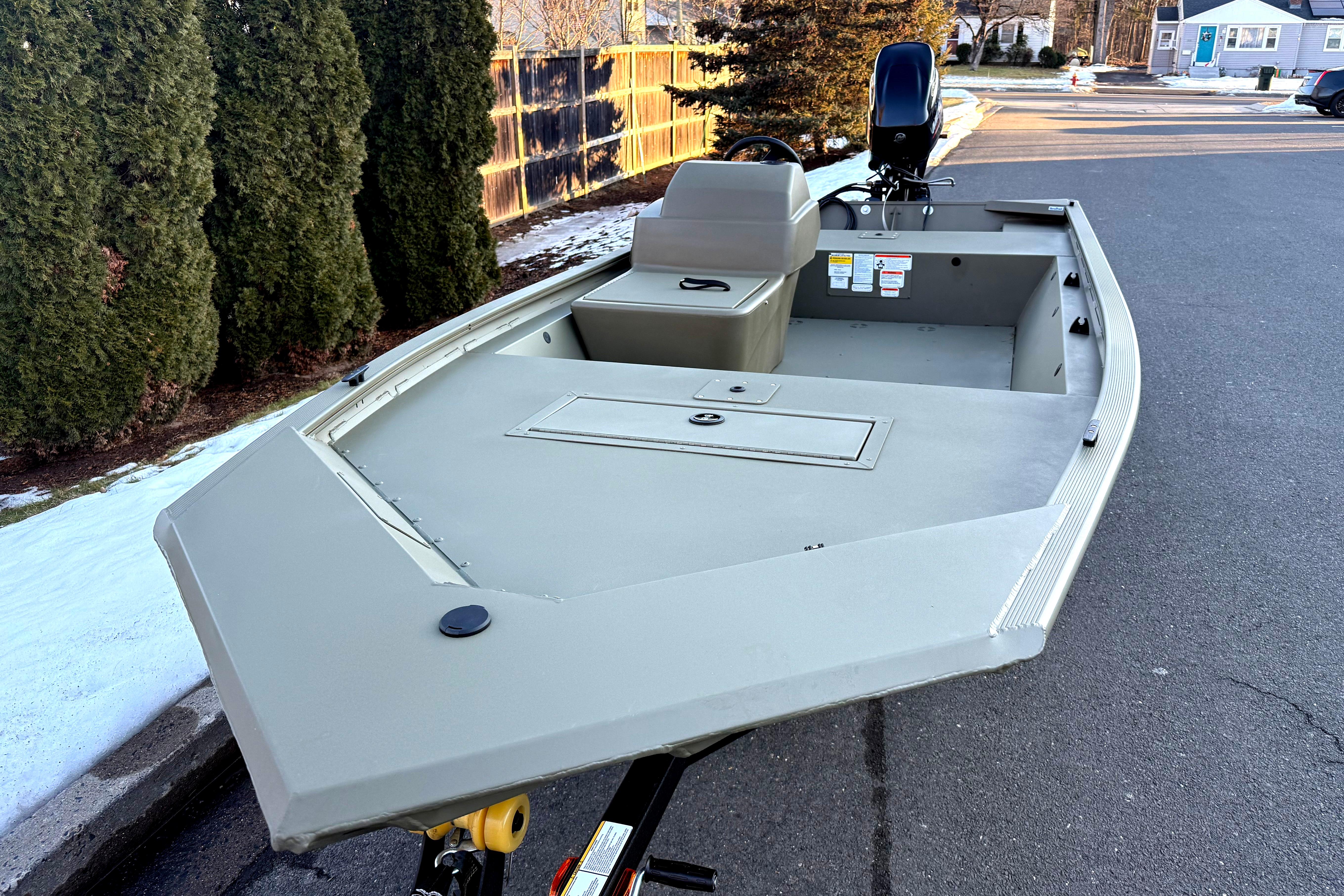 2026 Tracker Grizzly 1648 SC boat on trailer, parked on a snowy street.