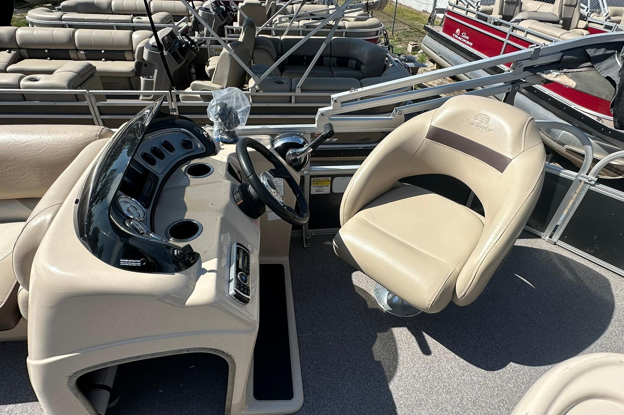2016 SUNTRACKER Party Barge 20 boat interior with steering console and captain's chair.