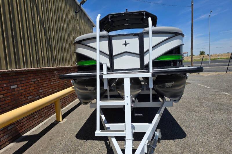 2026 Berkshire STS Arch Performance Series pontoon boat on trailer, parked outdoors.