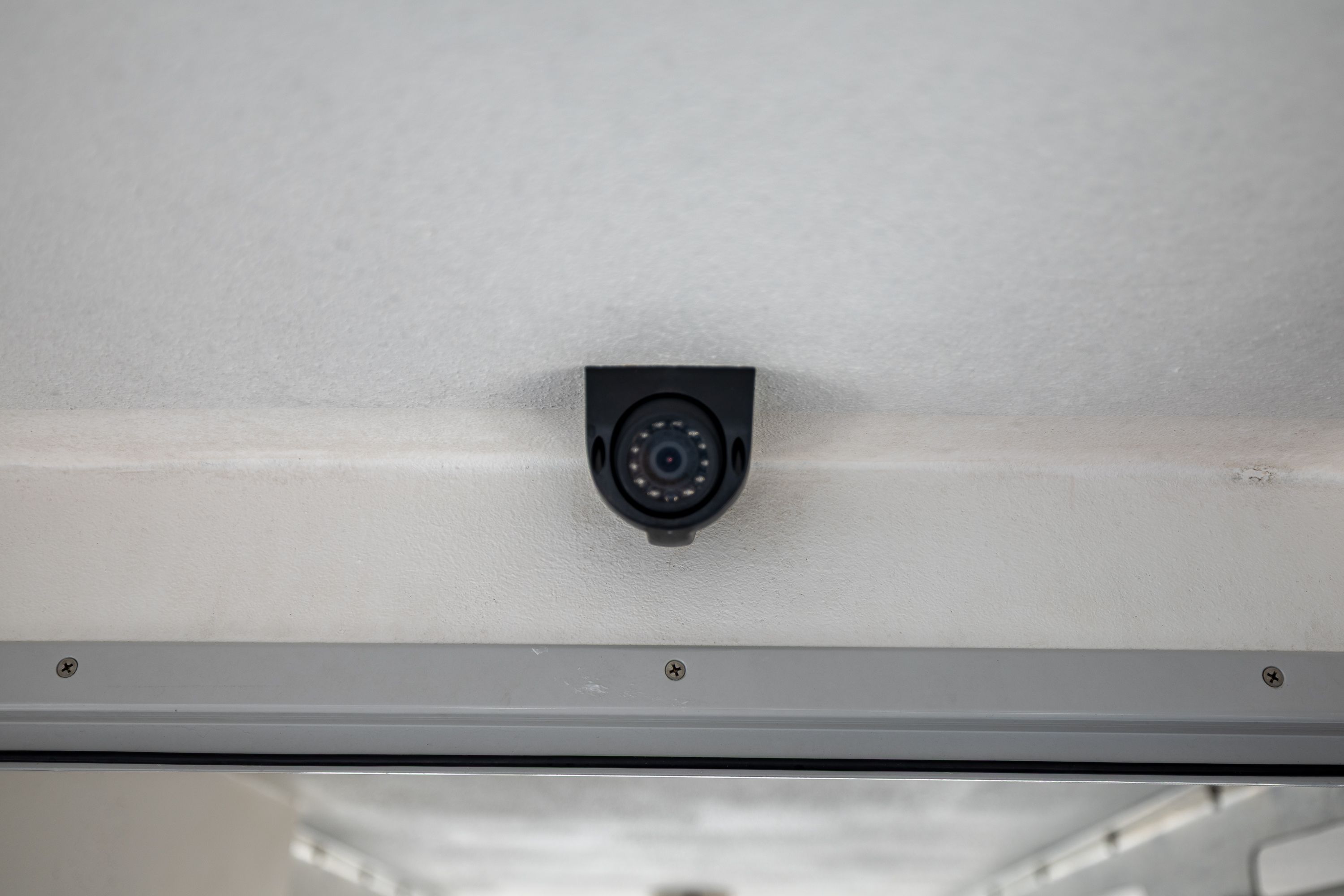 A surveillance camera is mounted on the ceiling of a boat.
