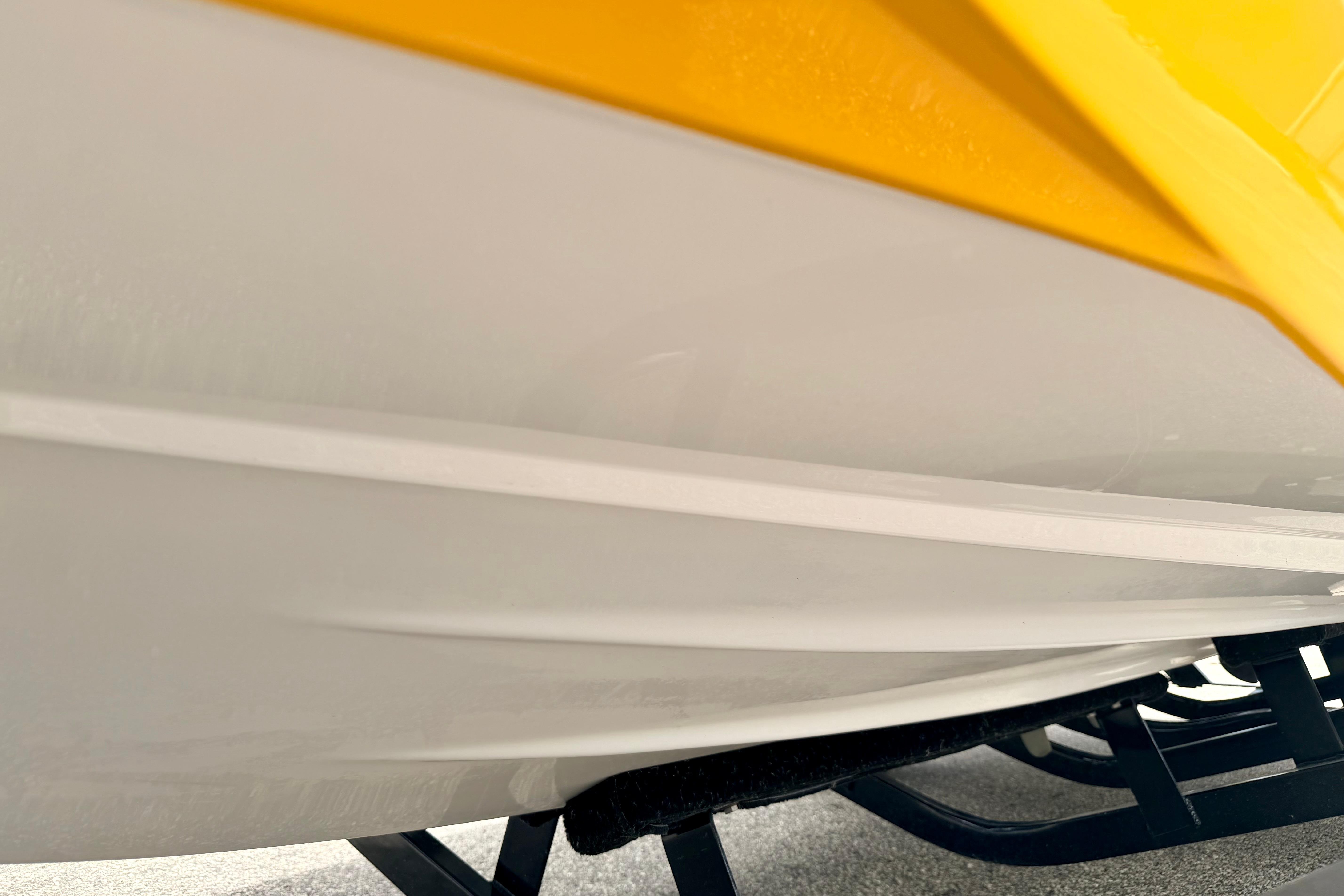 Close-up of 2014 Tigé R20 boat hull with yellow and white design.