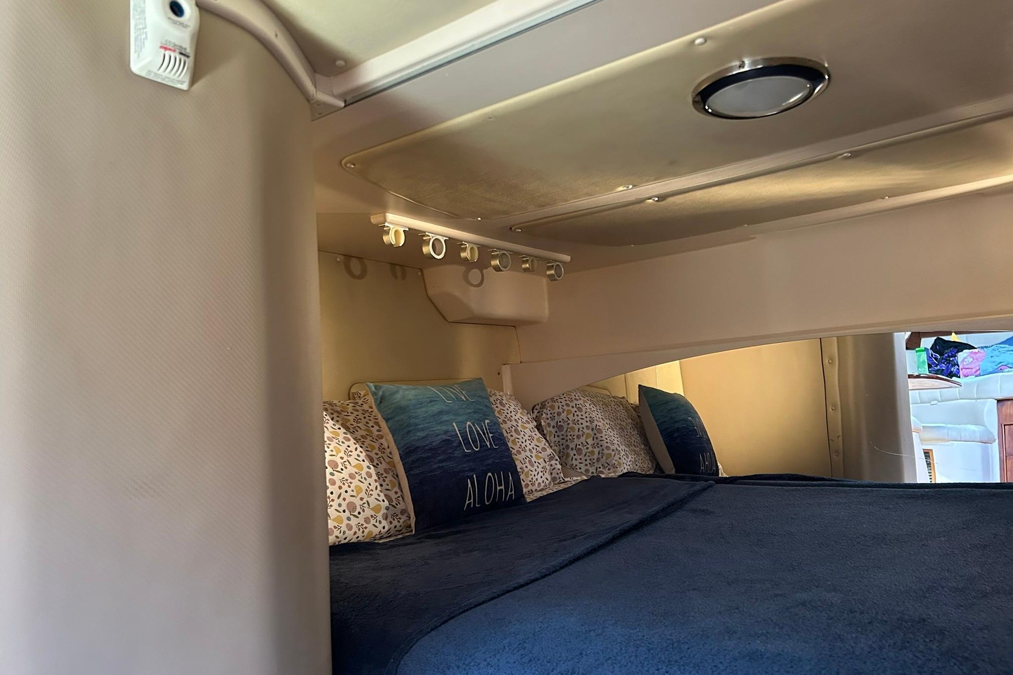 2007 Grady-White Express 360 cabin interior with cozy bedding and ambient lighting.