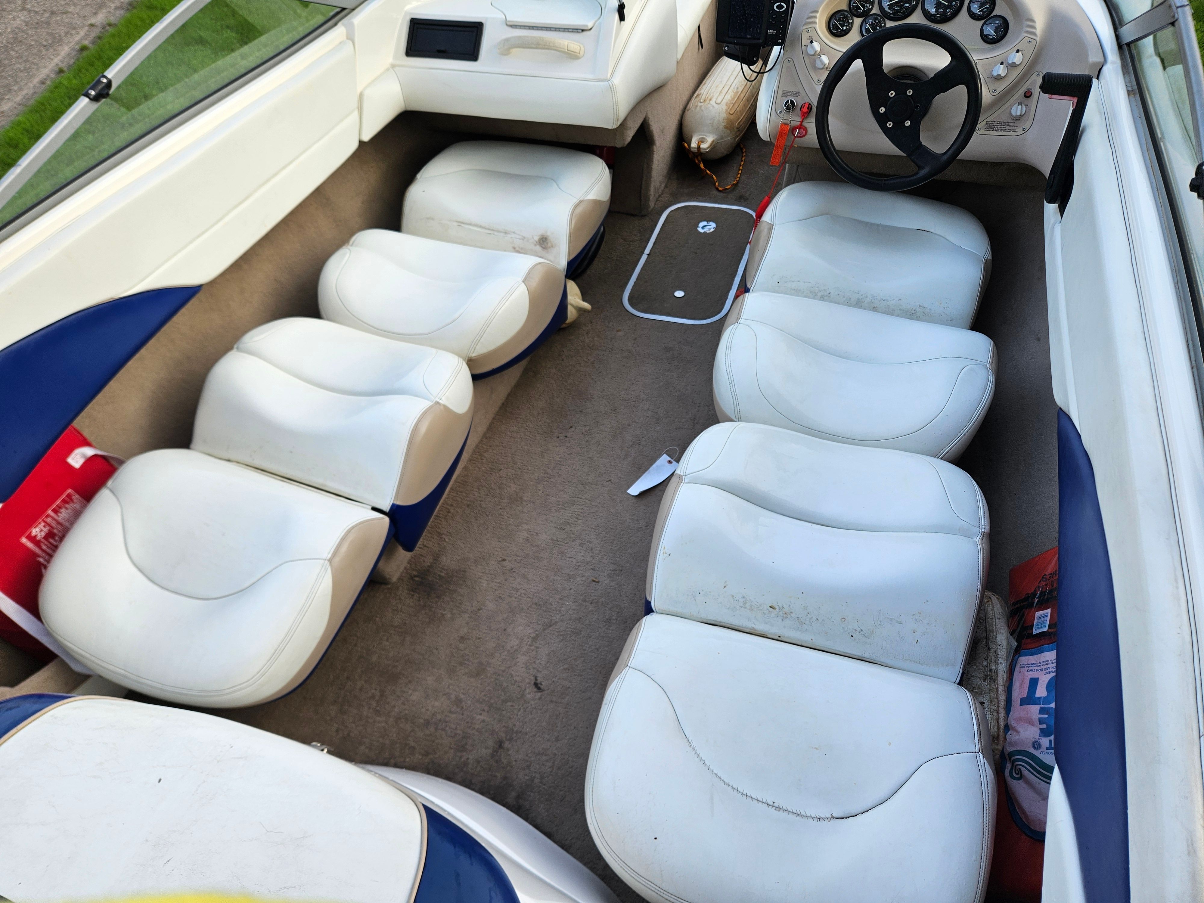 Interior of a 1996 Wellcraft Excel with white and blue seating and a helm station.
