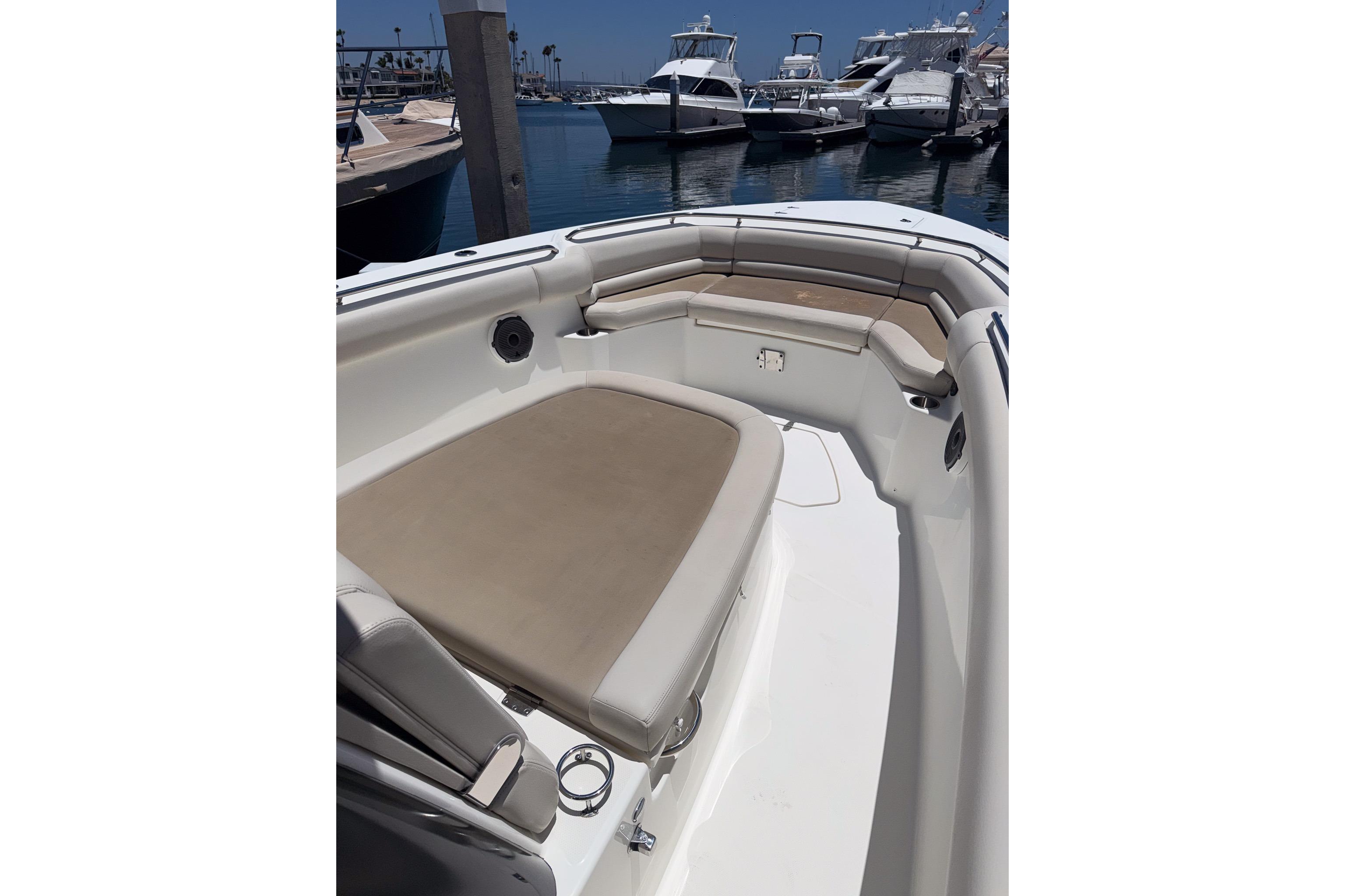 2021 Boston Whaler 330 Outrage boat interior with cushioned seating in marina.