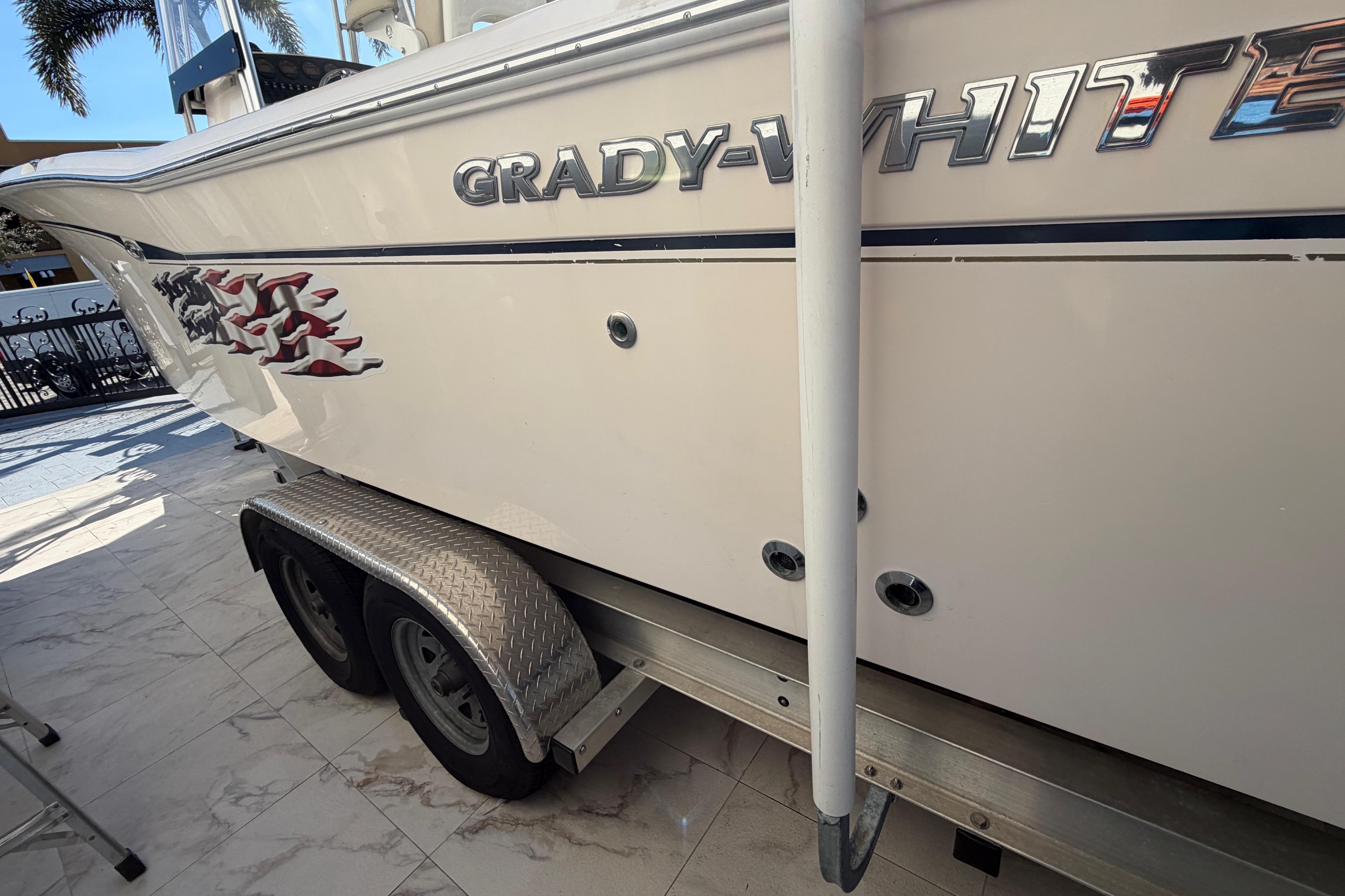 2004 Grady-White 273 boat on trailer, side view with logo and graphics.