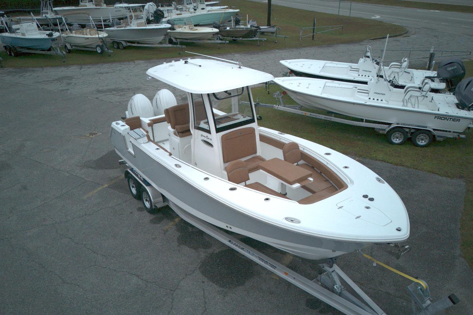 2026 Sea Hunt Gamefish 25 boat on trailer, parked in a marina lot.