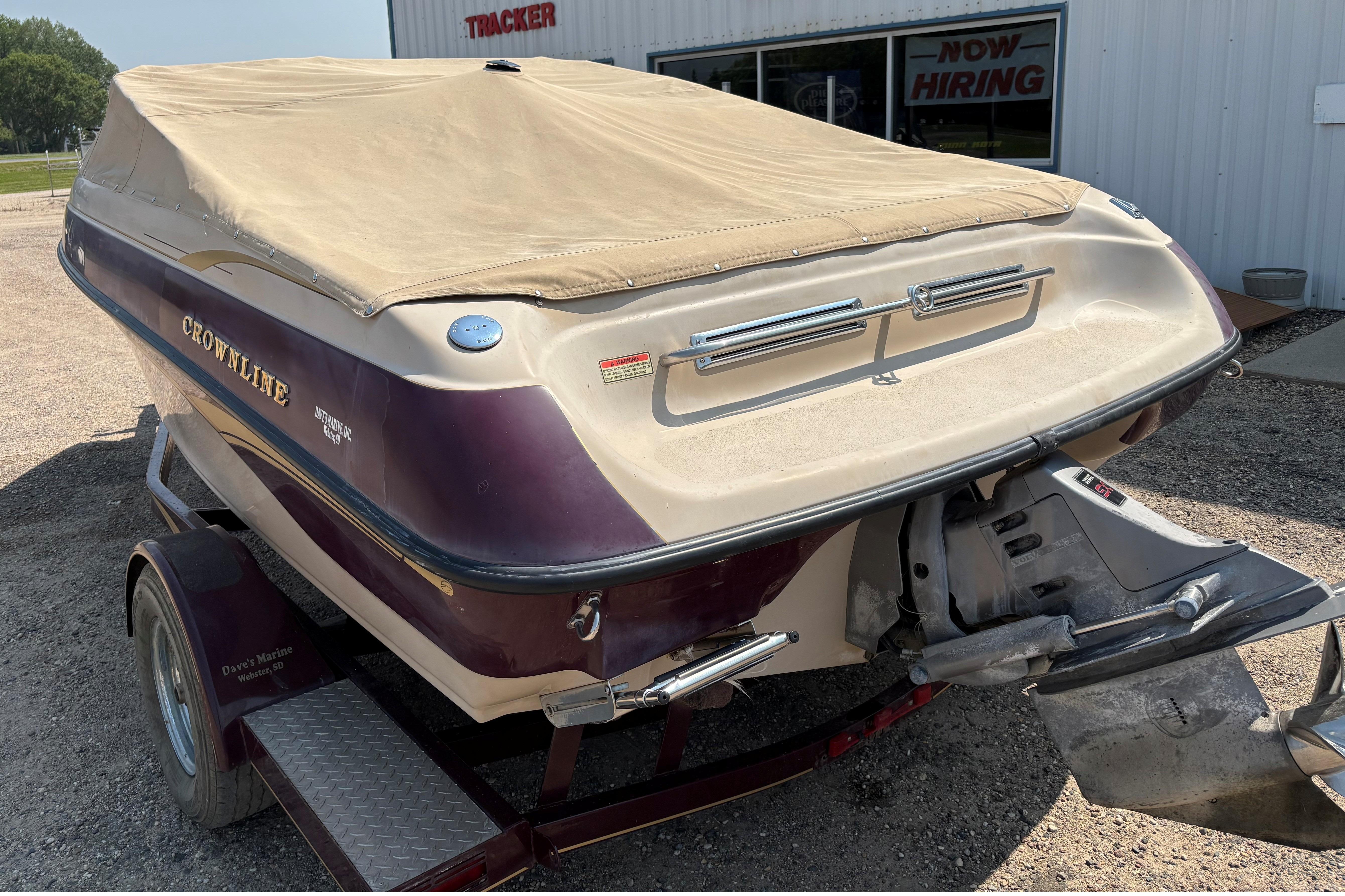 2001 Crownline 18' boat with cover on trailer, parked outside a building.
