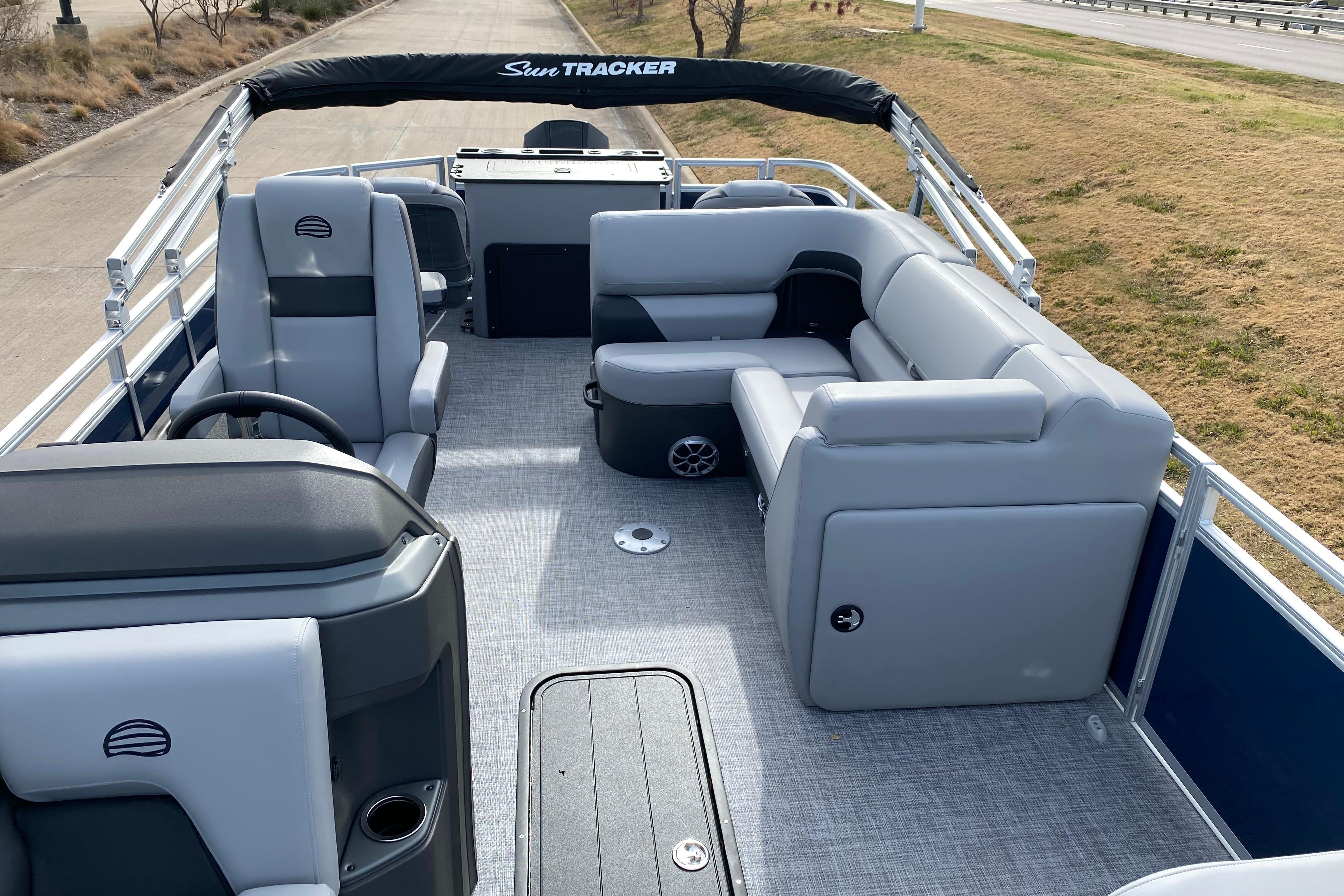 2026 Sun Tracker SportFish 22 XP3 pontoon boat interior with gray seating and helm.