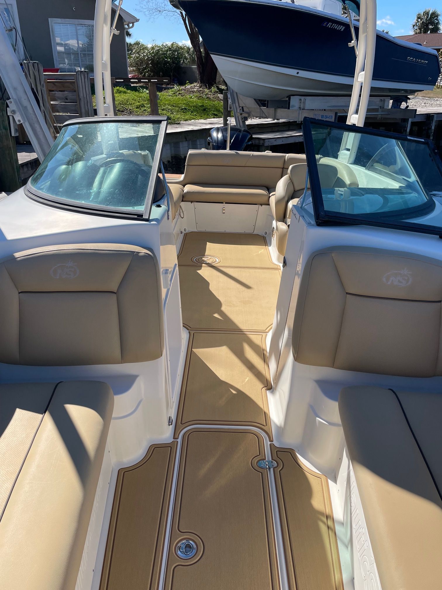 2019 NauticStar 243DC Sport Deck boat with beige interior and glass windshields.