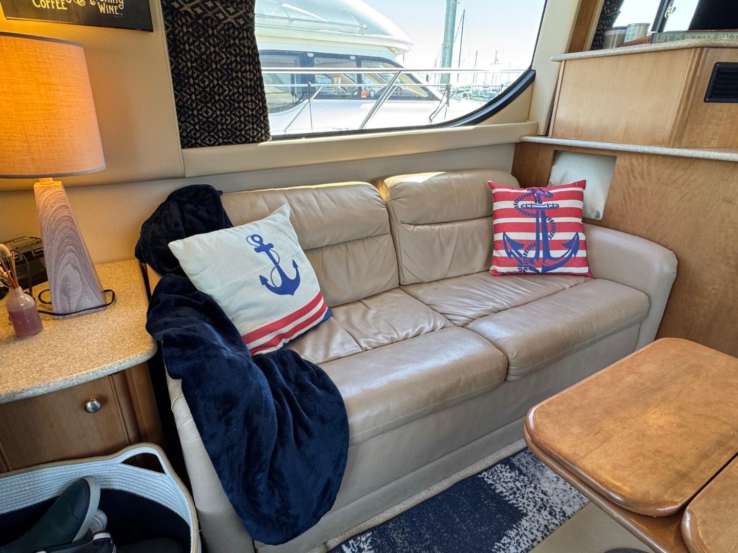 Luxurious 2003 Meridian 381 Sedan interior with nautical-themed pillows and cozy seating.