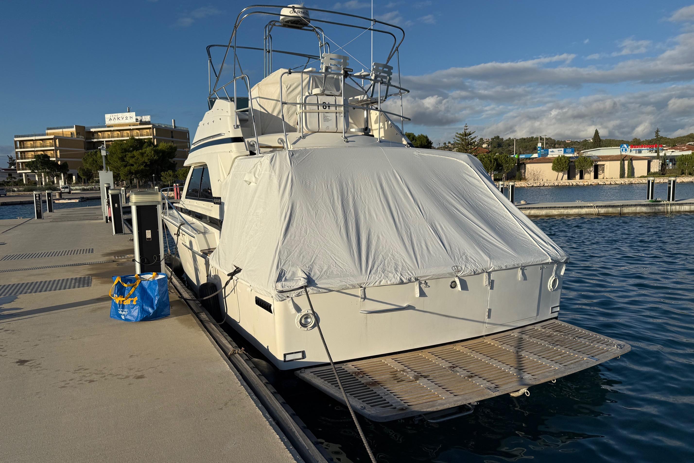 1987 Bertram 37 Convertible yacht docked, covered, with clear skies and waterfront view.