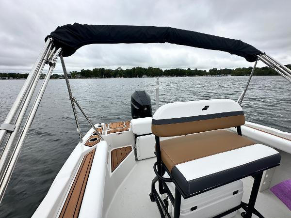 2025 Starcraft SVX 211 OB CC boat interior with seating, on a calm lake.