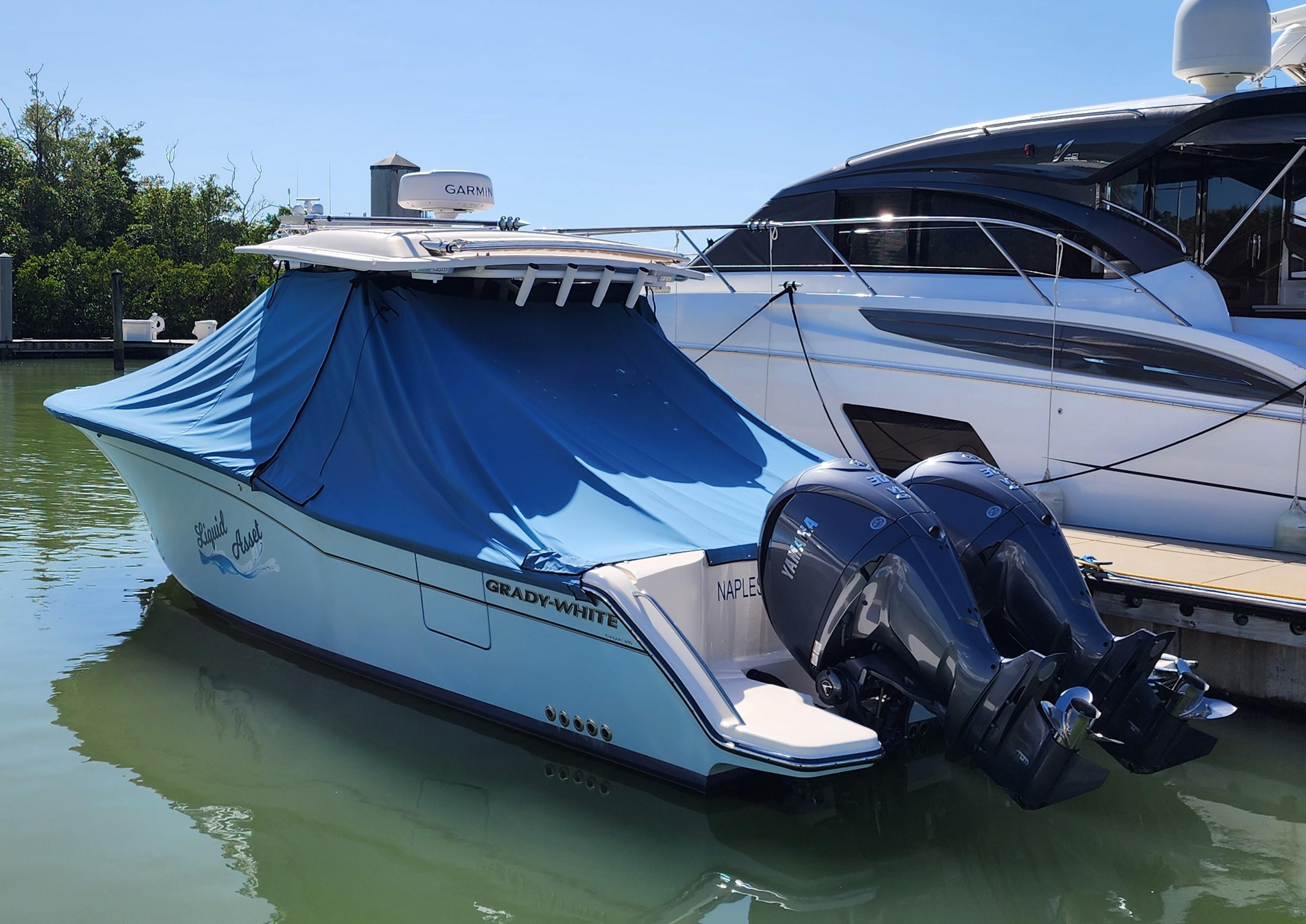 2022 Grady-White 326 CANYON boat docked with blue cover and twin outboard motors.