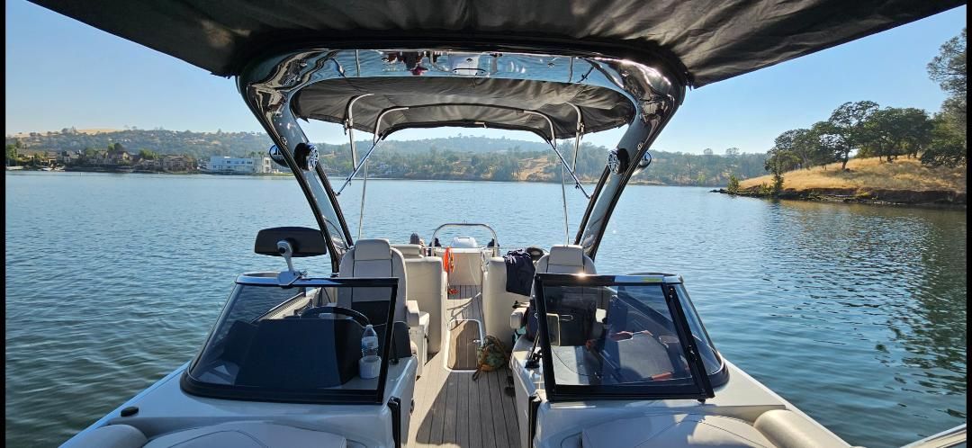 2021 Avalon Excalibur Elite boat on a tranquil lake.