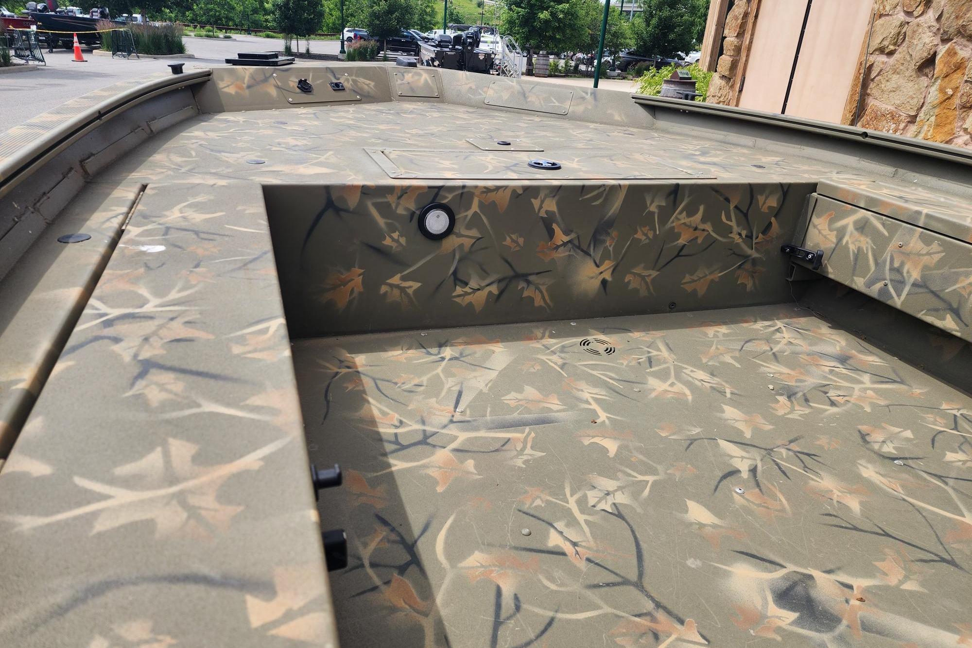 2022 GRIZZLEY 1654SPT boat interior with camouflage pattern, parked outdoors.