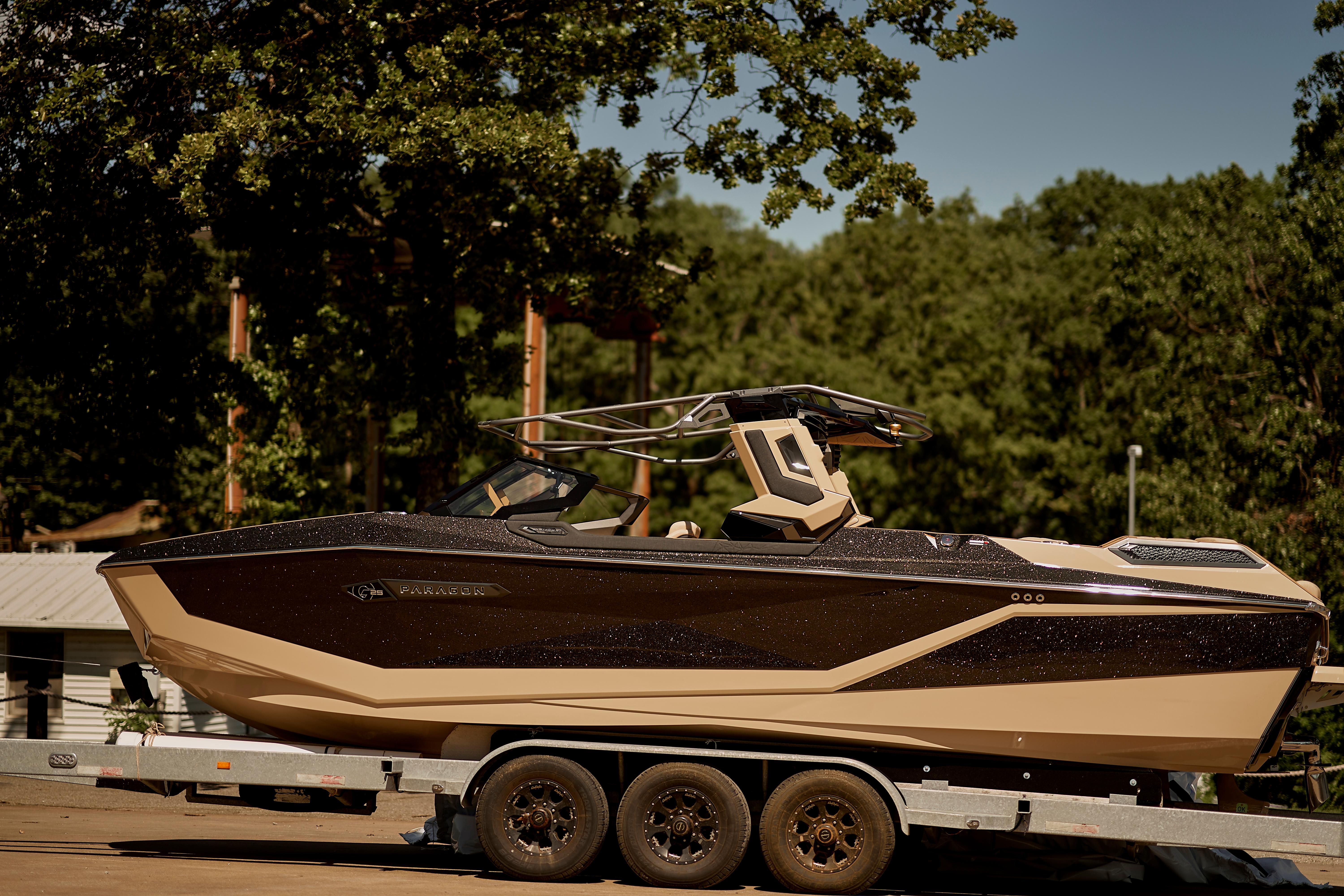 2025 Nautique Super Air Nautique G25 Paragon on trailer, surrounded by trees.