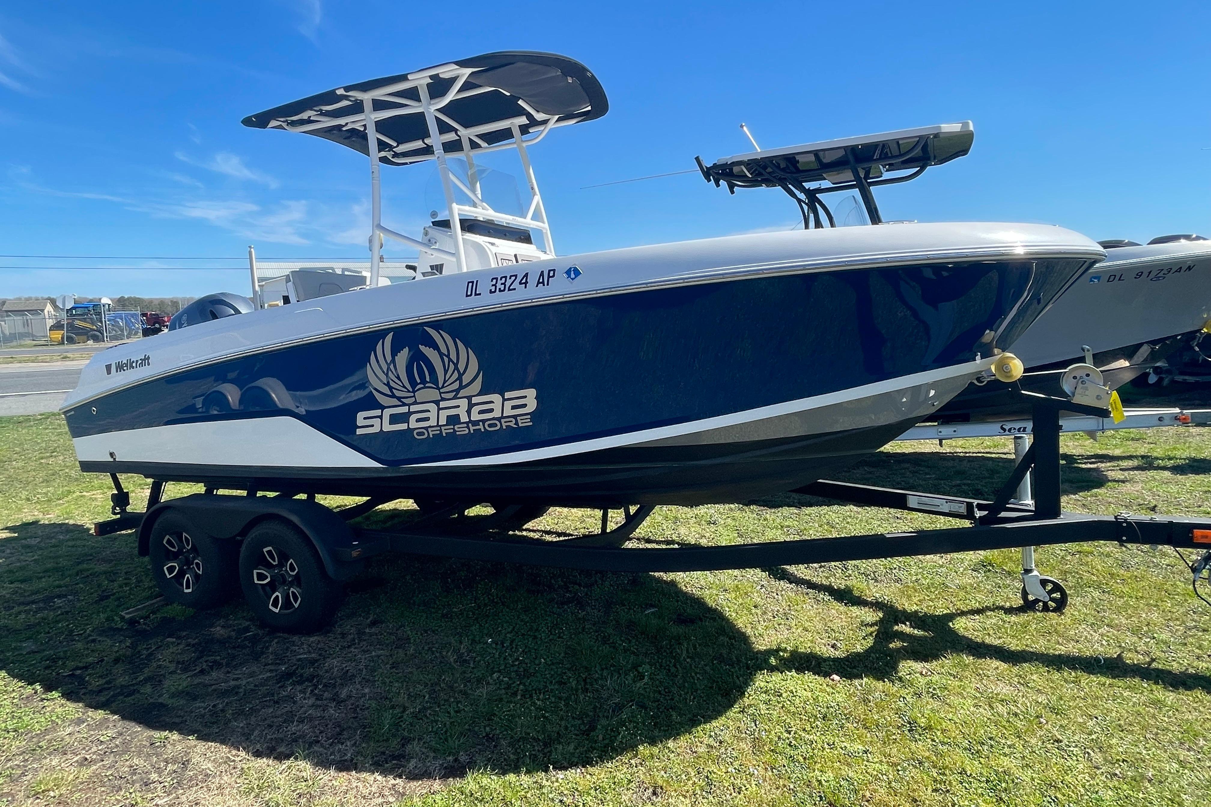 2022 Wellcraft 202 Fisherman boat on trailer, blue and white design, Scarab Offshore branding.