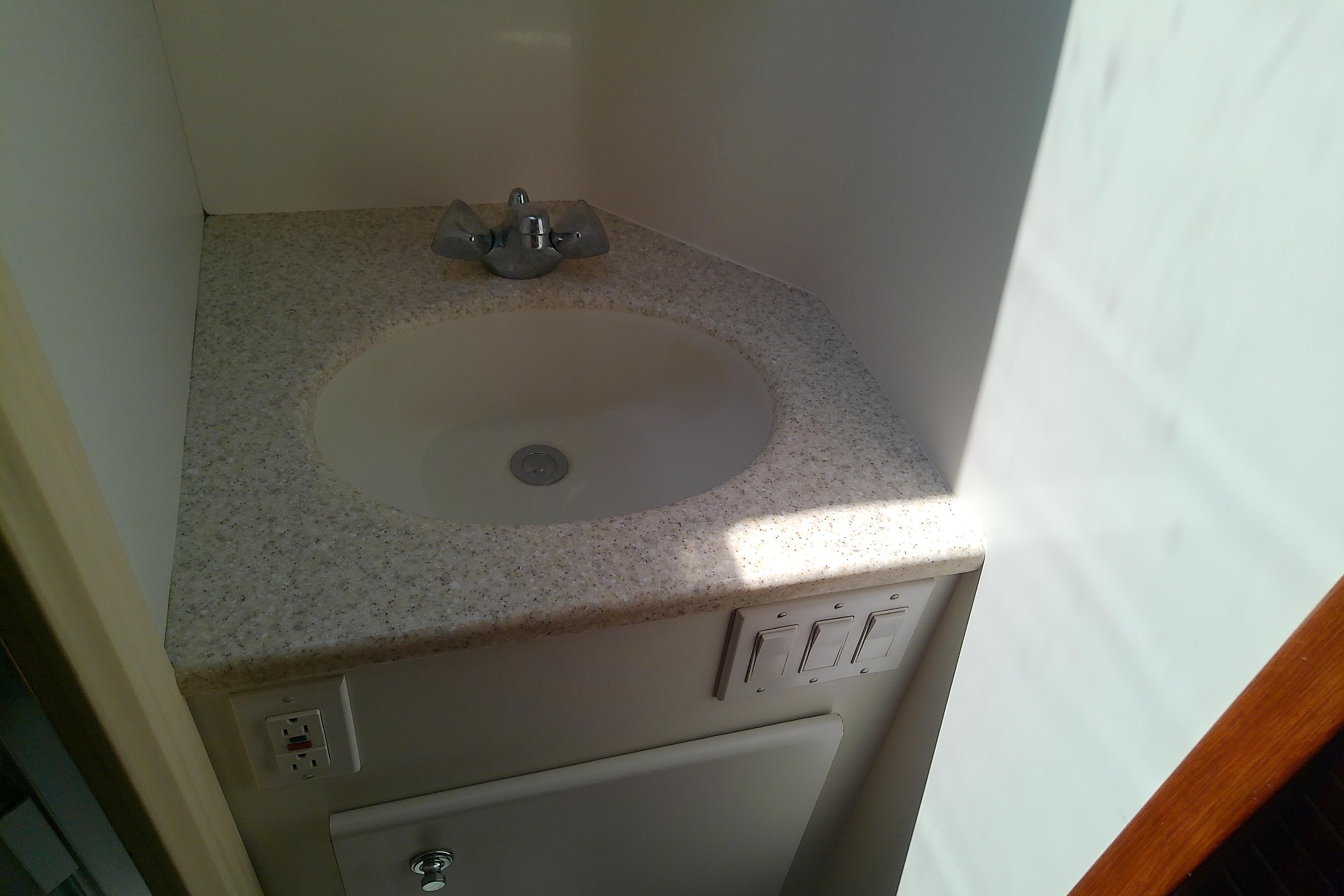 Compact bathroom sink in 2000 Tiara Yachts 4100 Open, featuring a modern countertop design.