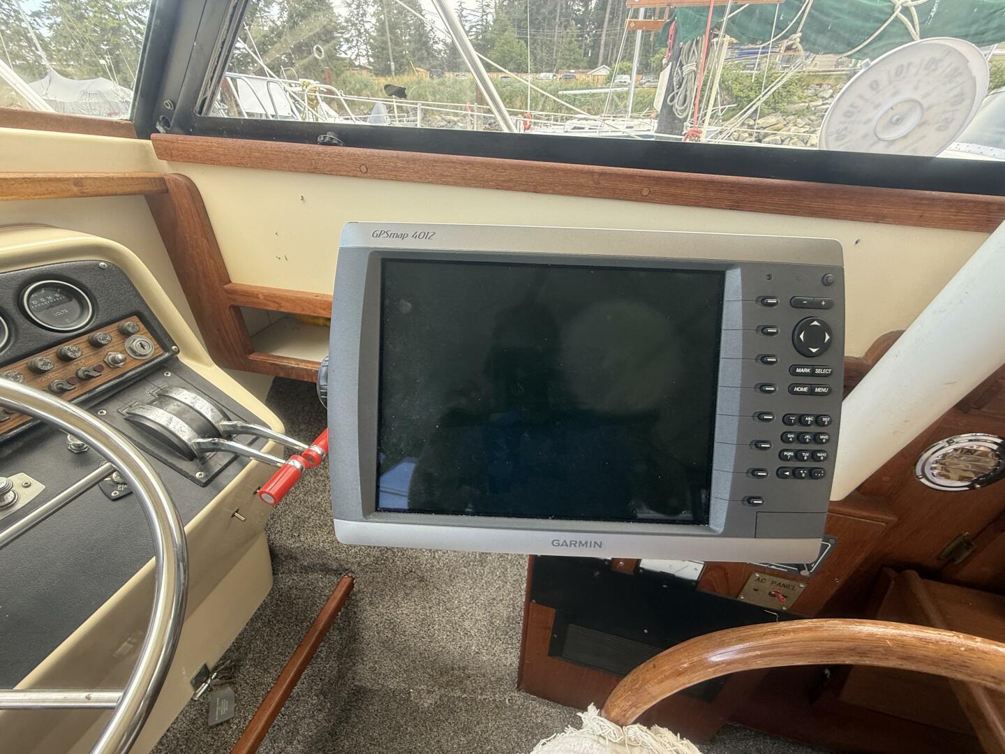 1980 Silverton 34 Convertible helm with Garmin GPSmap 4012, steering wheel, and controls.