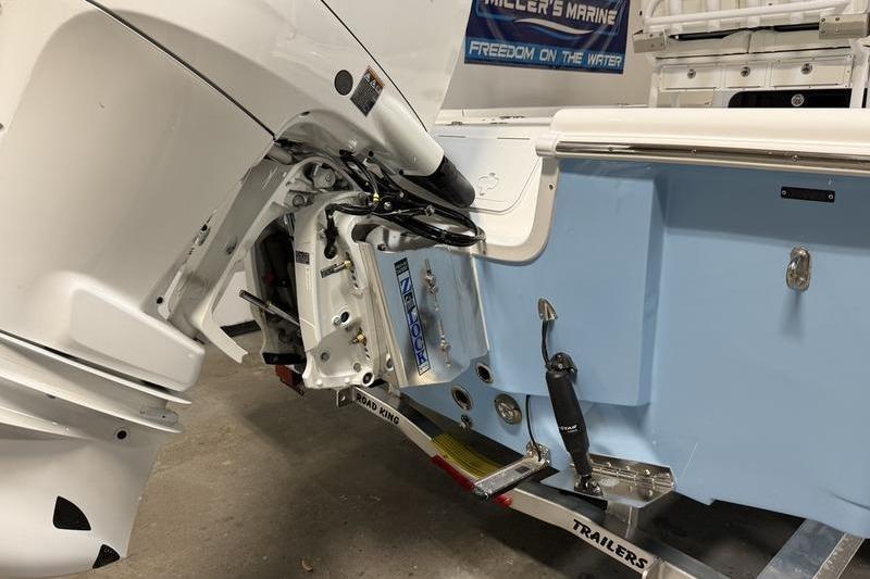 2026 Sea Pro 250 Bay boat on trailer, showcasing engine and hull details.
