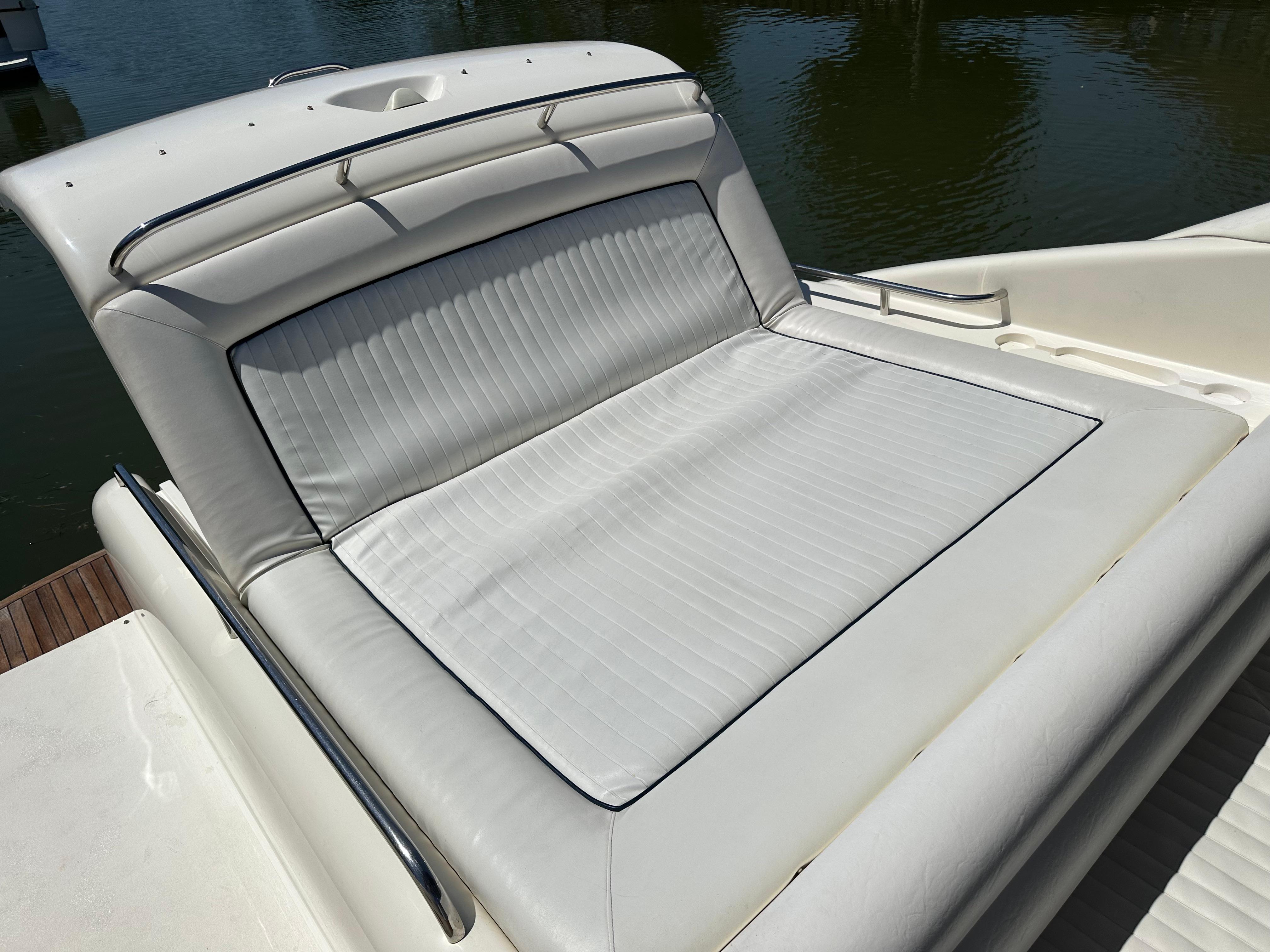 Sunseeker Camargue 47 (1997) yacht sunbed with white cushioned seating by the water.