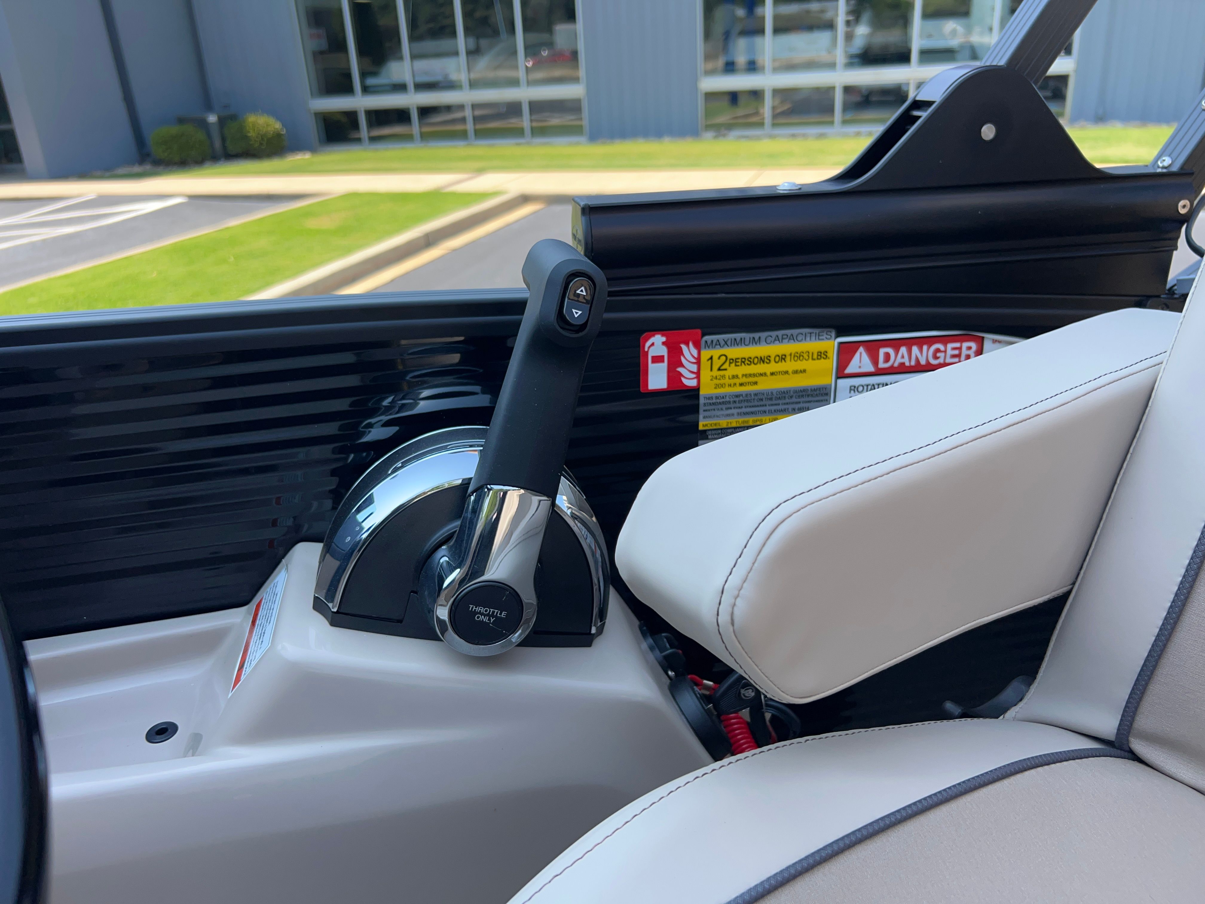 Close-up of the throttle lever on a Bennington 22 MFB boat, surrounded by beige upholstery.