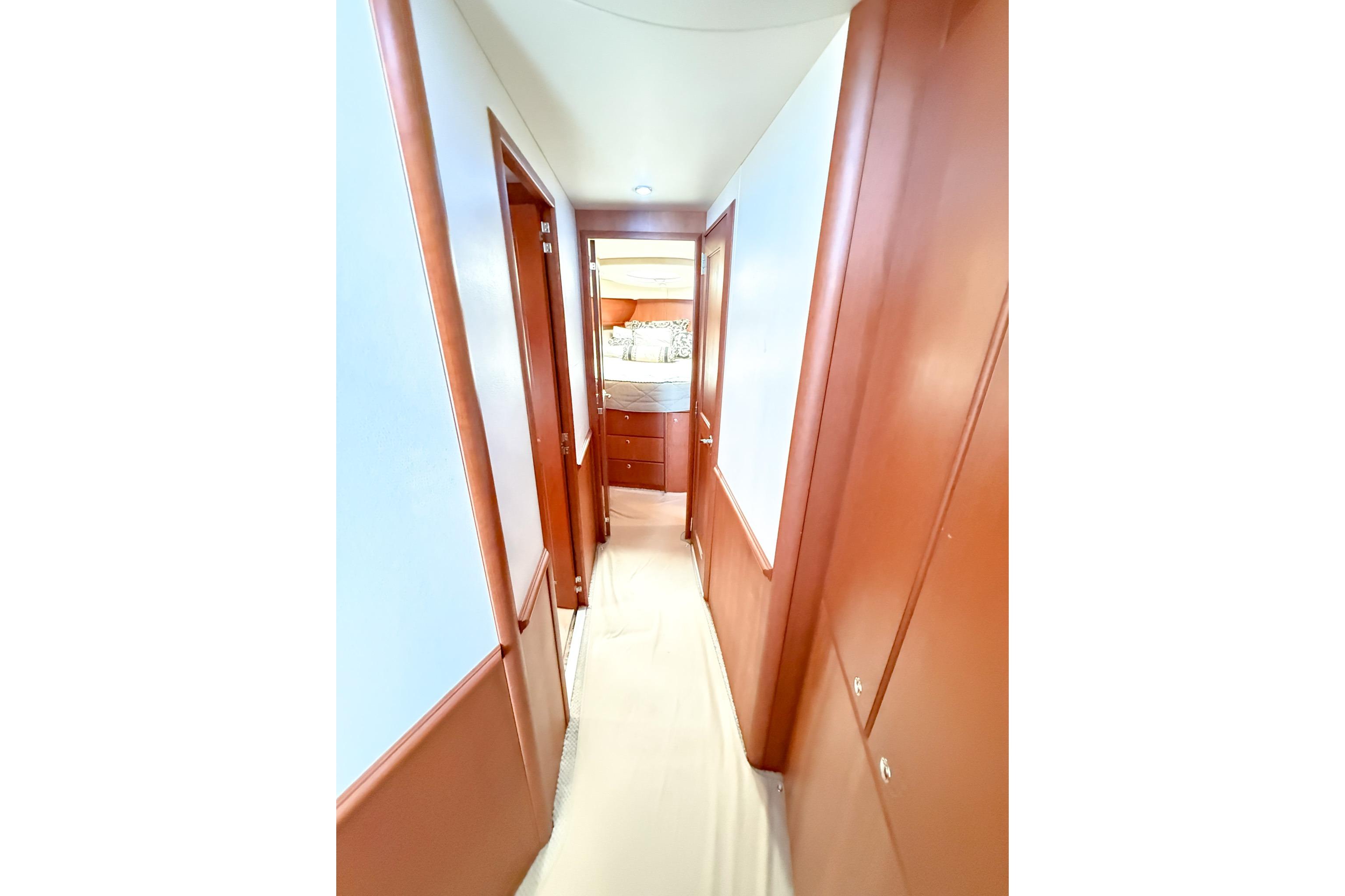 Hallway inside 2004 Silverton 48 Convertible yacht, featuring wooden paneling and a view into a cabin.