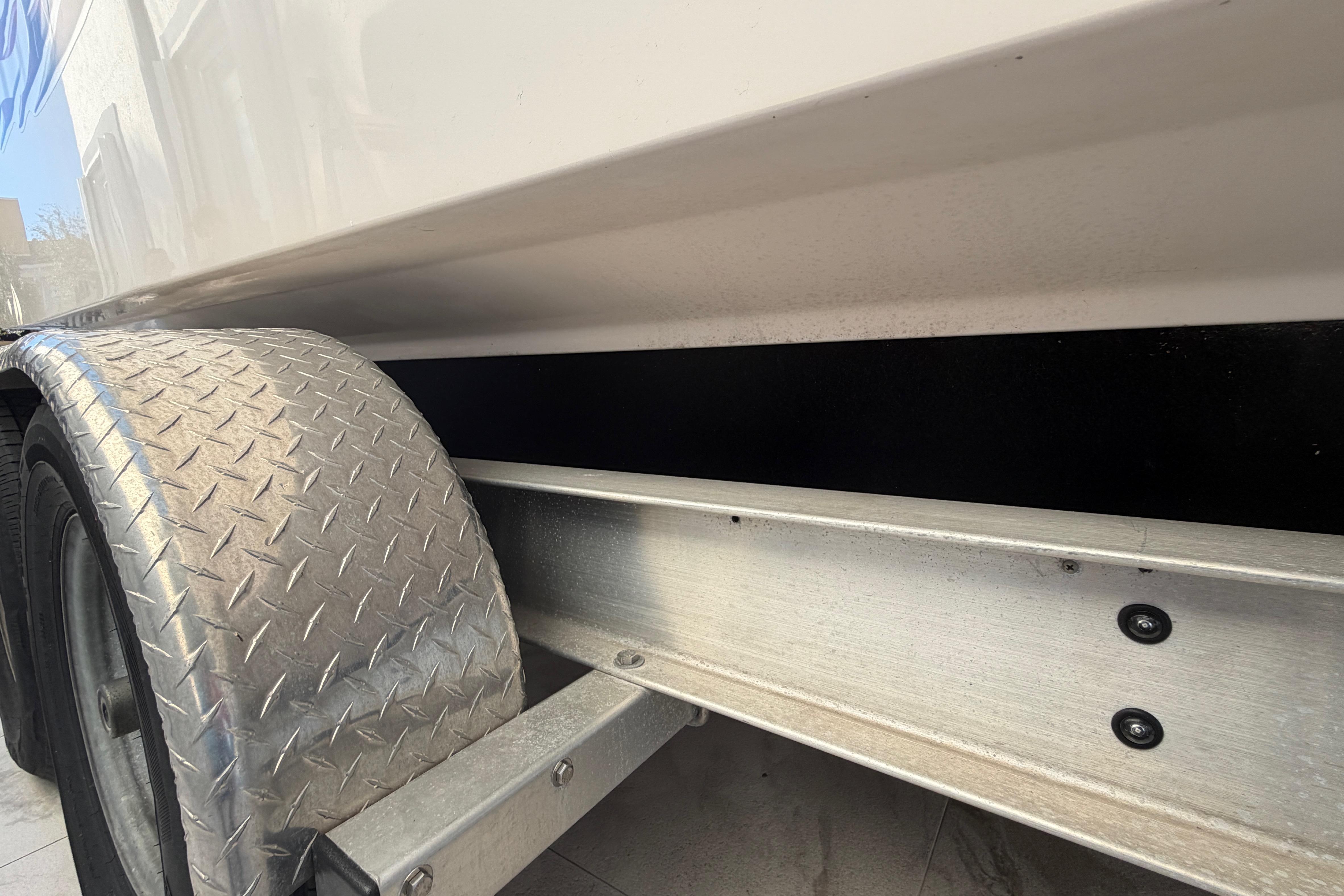 Trailer wheel and side view of 2004 Grady White 273 boat.