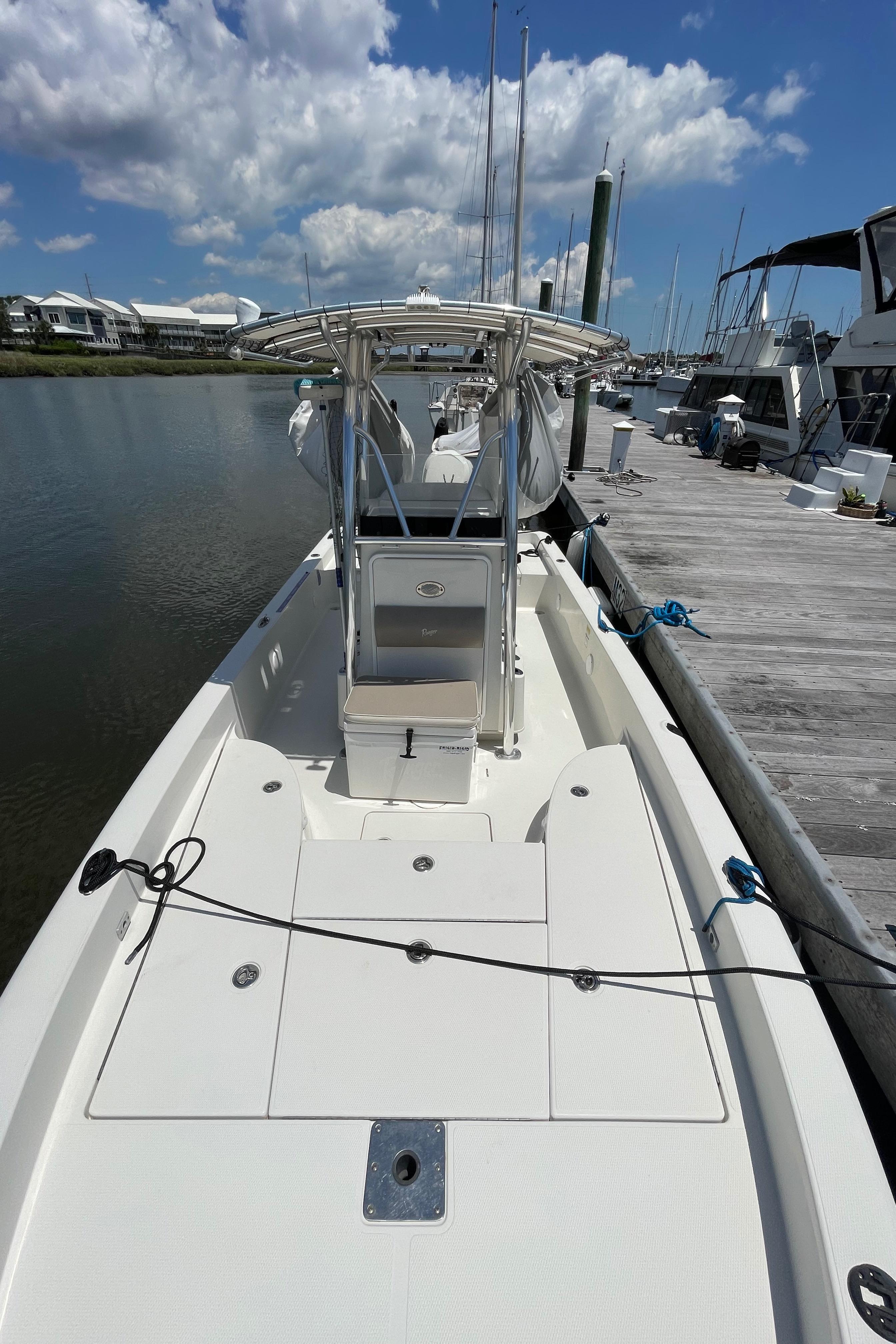 2012 Ranger 2410 Bay Ranger boat docked at marina under blue sky.