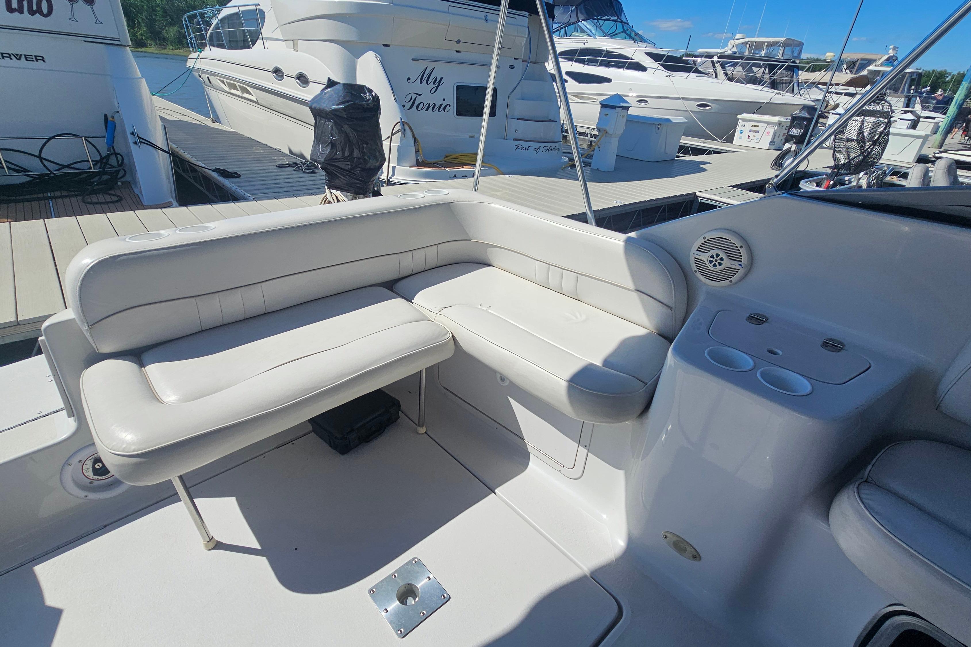 2000 Crownline 242 CR boat interior with white seating and cup holders at a marina.