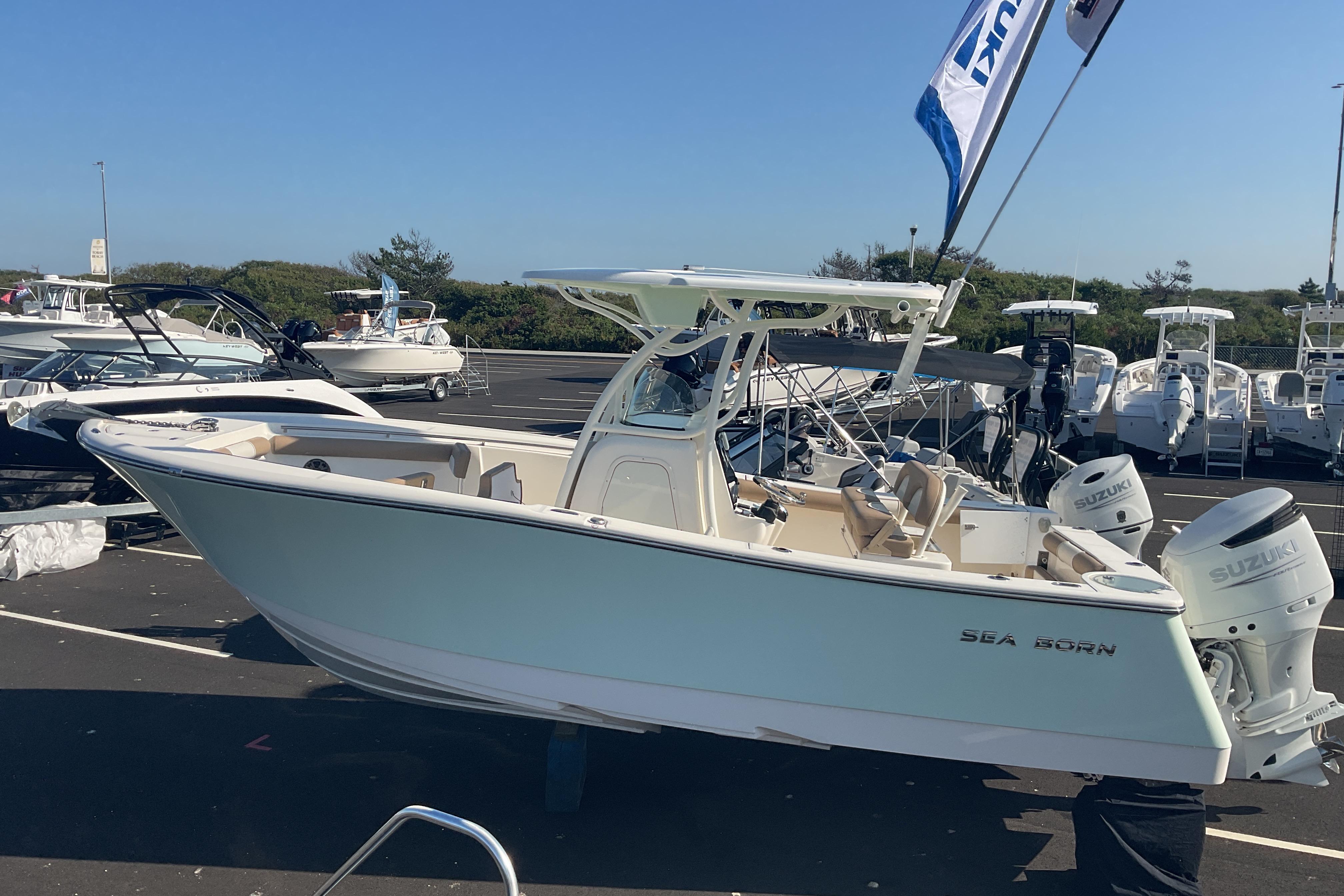 2023 Sea Born SX239 Offshore boat with dual Suzuki engines in a marina setting.