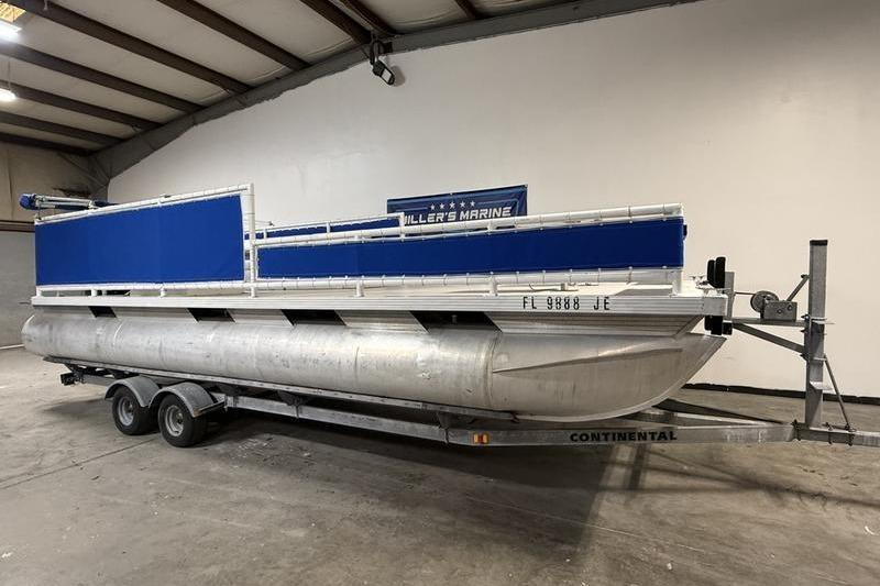 1993 Monark Sun Caster 240 CR 4 Point pontoon boat on trailer in warehouse.