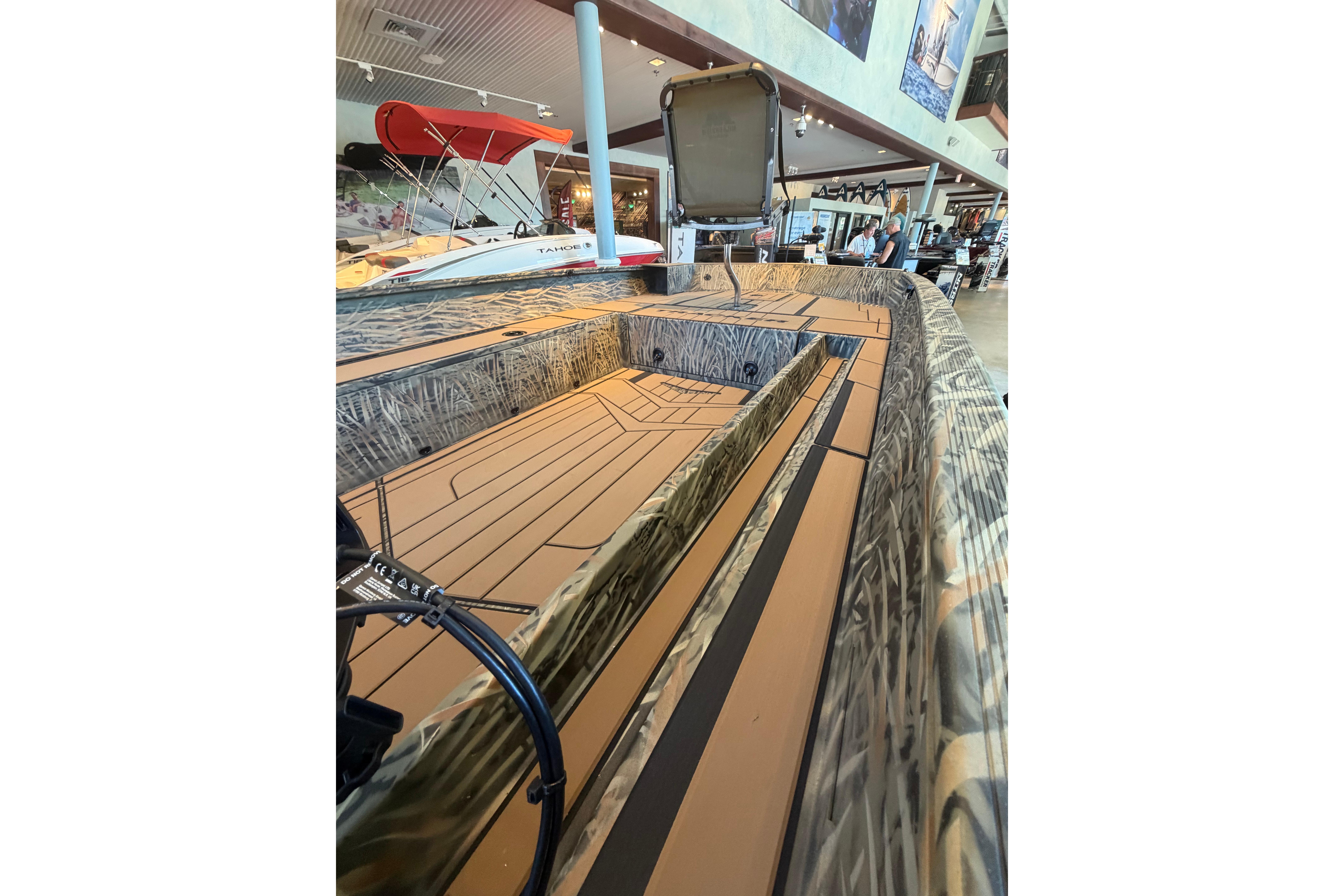 2026 Tracker Grizzly 1756 T Marsh boat interior with camouflage design in showroom.