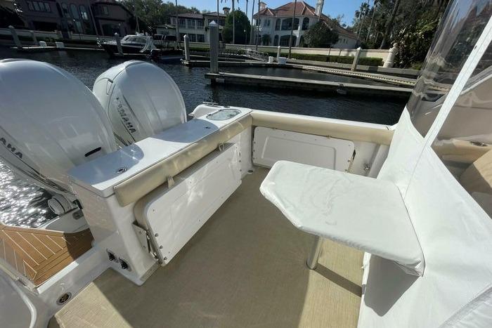 2022 Southport 33 DC boat interior with dual engines and seating area by the dock.