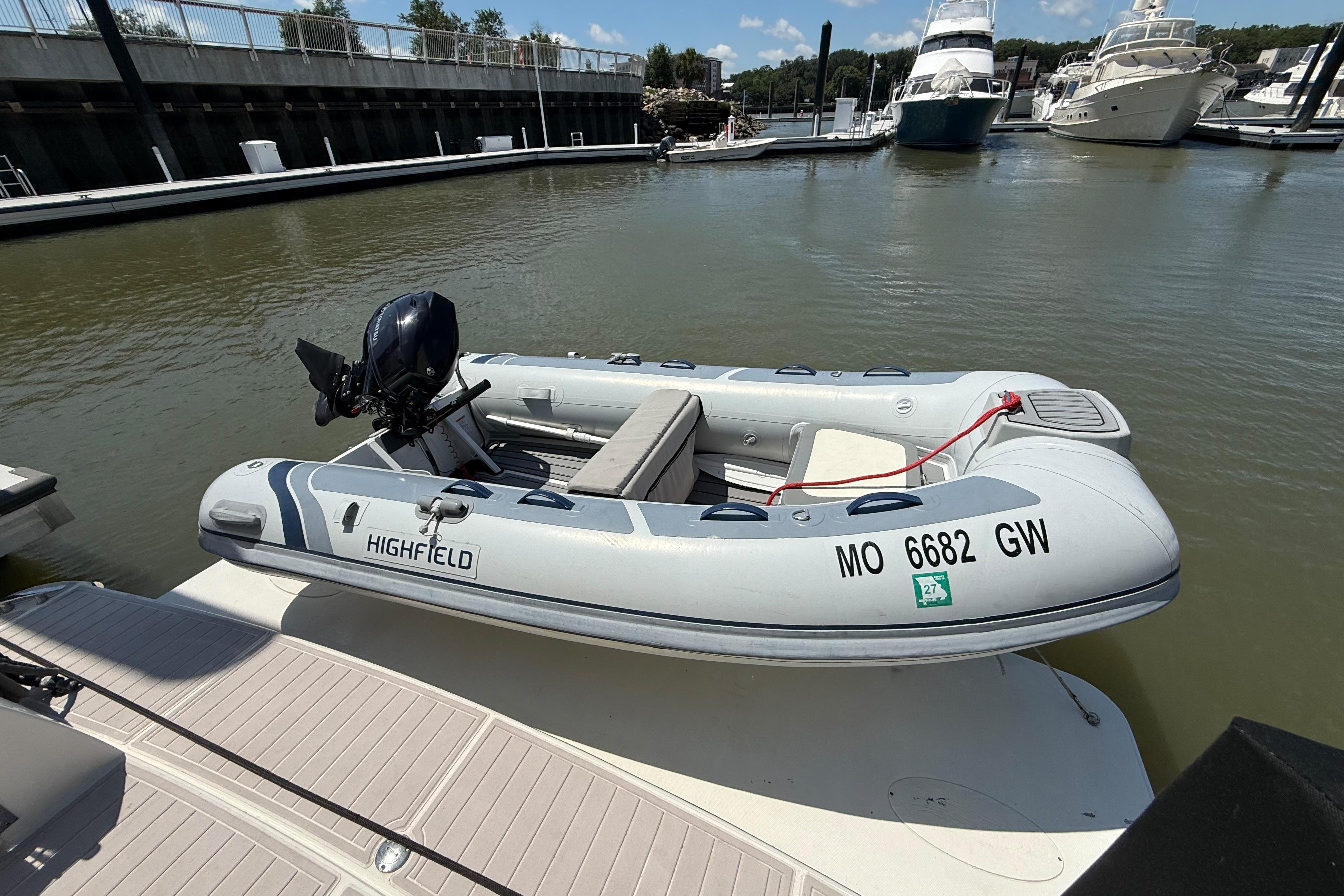 Highfield inflatable boat docked near Carver 43 Motor Yacht, 2006 model, in a marina.