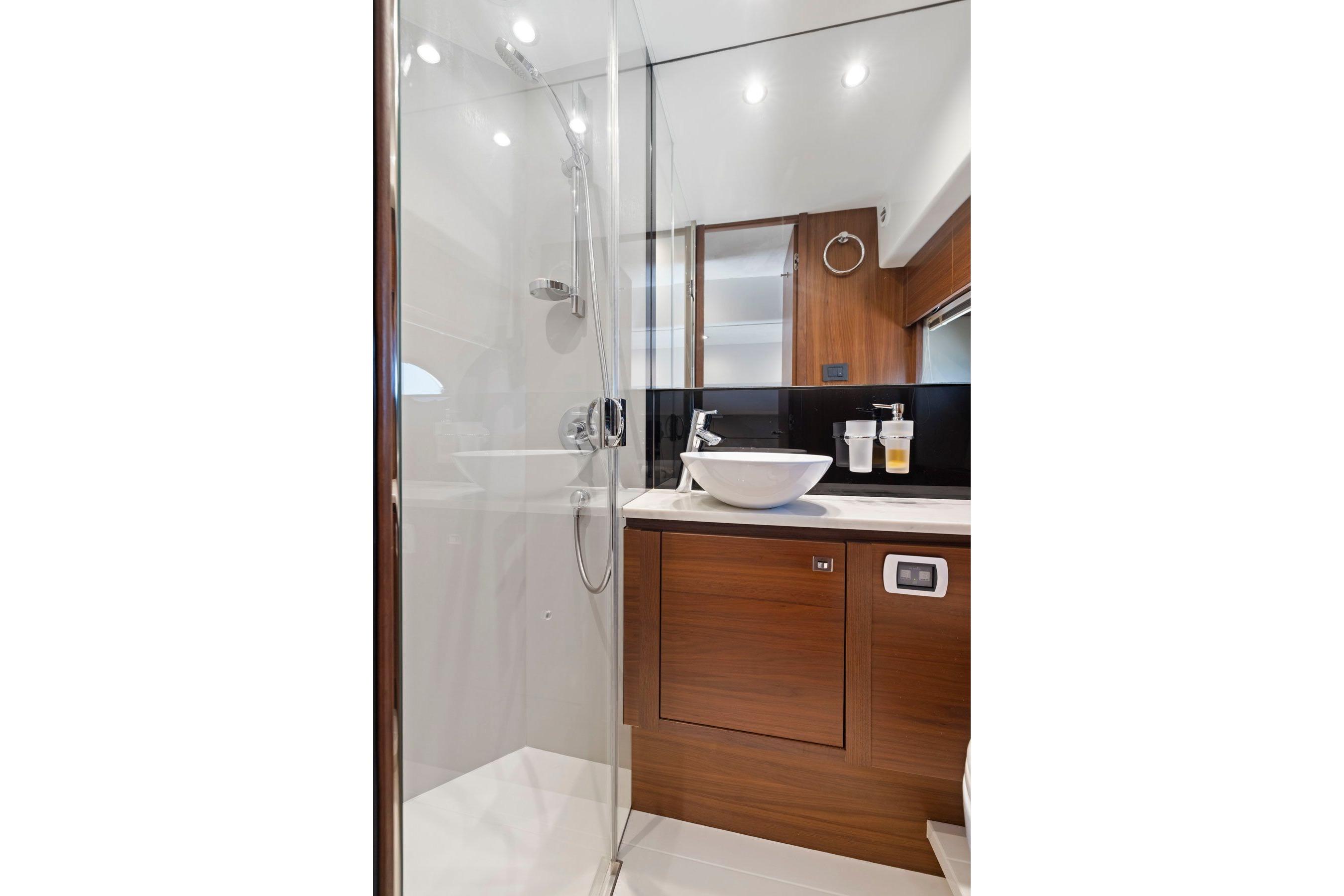 Luxurious bathroom in 2015 Princess 60 Flybridge Motor Yacht with modern fixtures and wood accents.