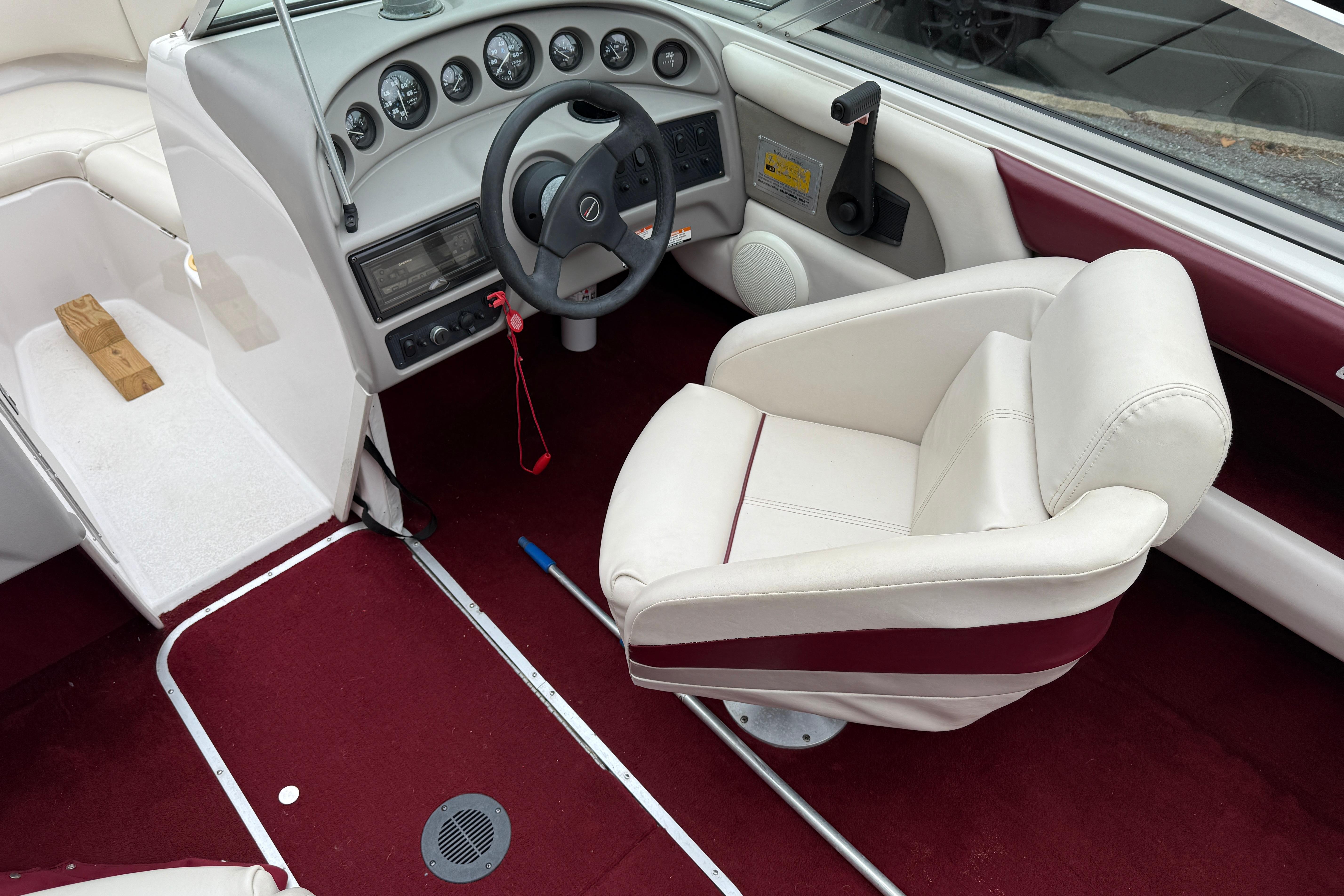 Interior of a 1999 Chaparral 1930 SS boat with red carpet and white seating.