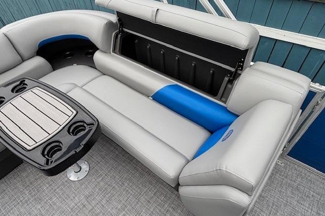 2026 Sun Tracker Party Barge 20 DLX interior with gray and blue seating, storage, and table.