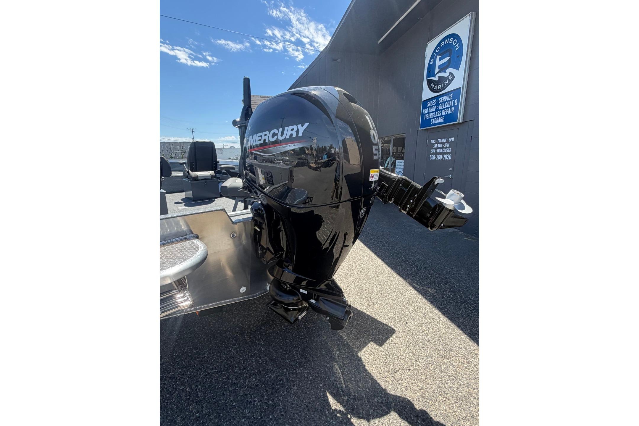 Outboard motor on a 2026 Thunder Jet 209 Rush OT boat, parked outside a marine service center.
