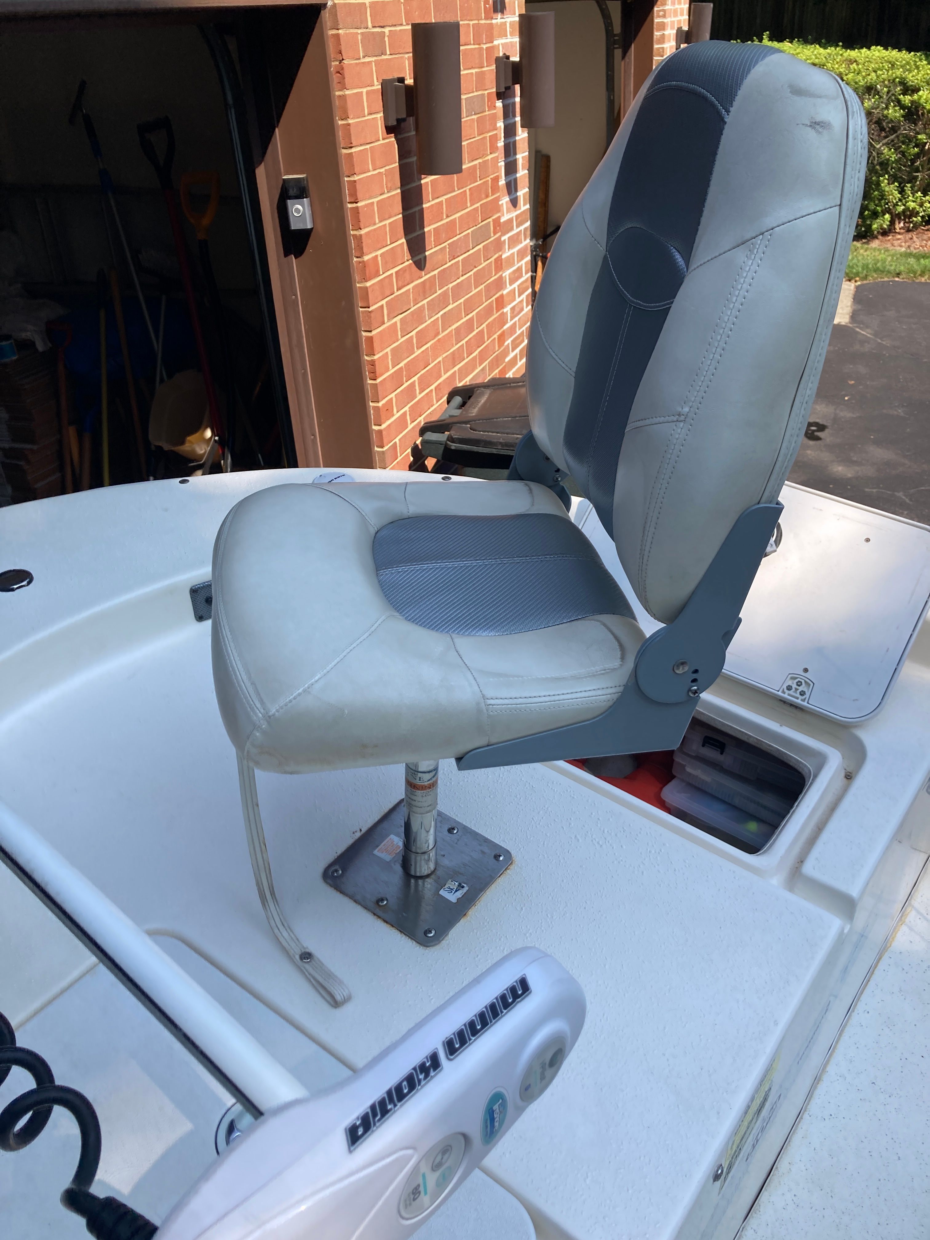A swivel captain's chair on a 2012 Carolina Skiff JVX16CC, parked in a garage.