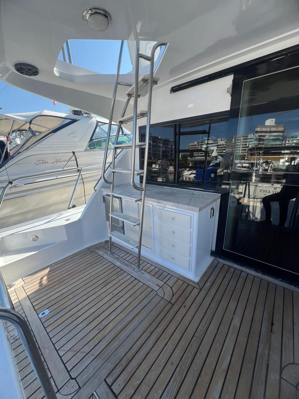 1995 Mikelson 60 Sportfisher with outdoor ladder and wooden deck.
