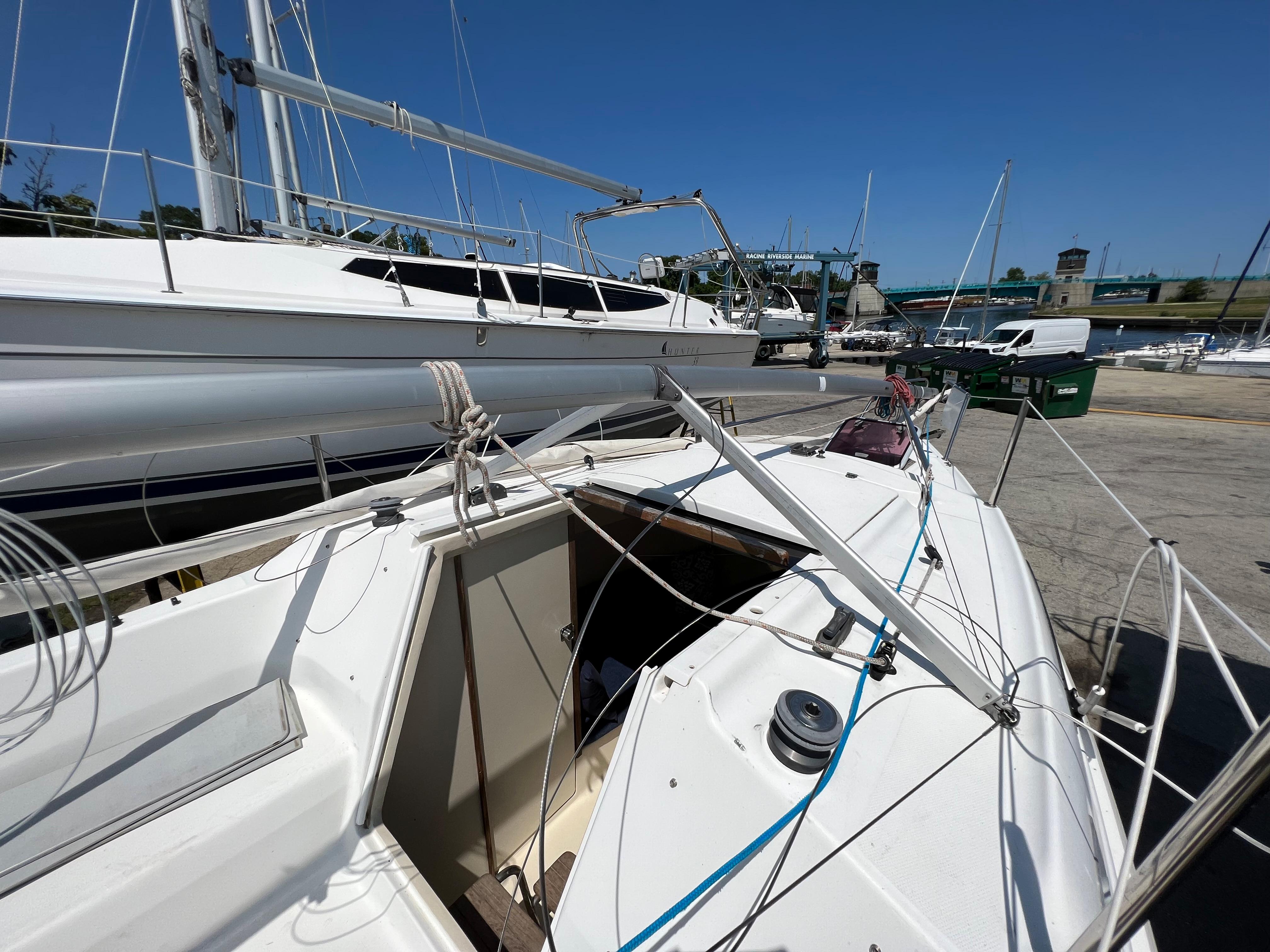 2007 Hunter 25 sailboat docked, showing deck and rigging under clear blue sky.