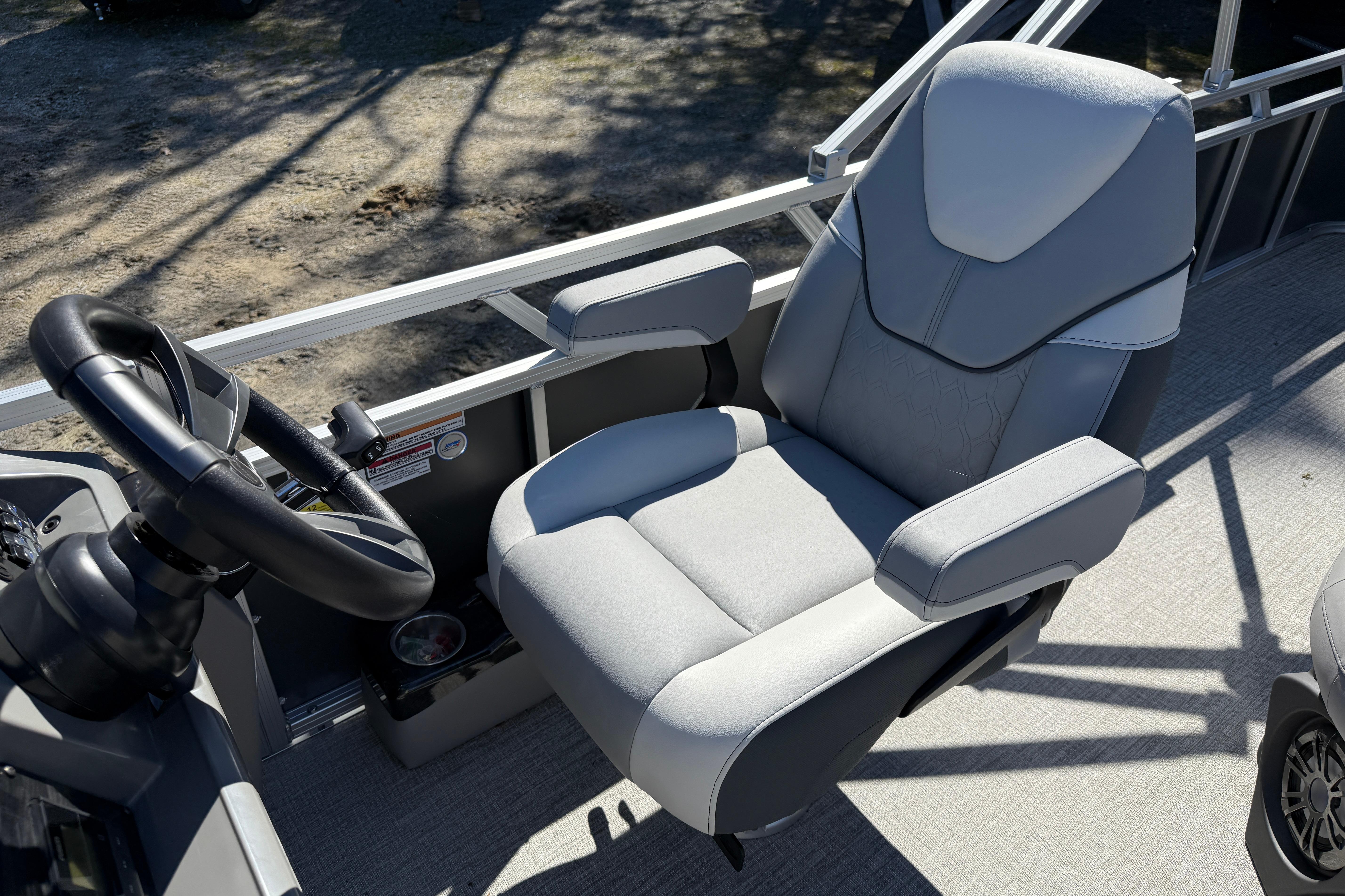 Captain's chair and steering wheel on 2026 Tahoe Pontoon Sport 85 Rear Fish boat.