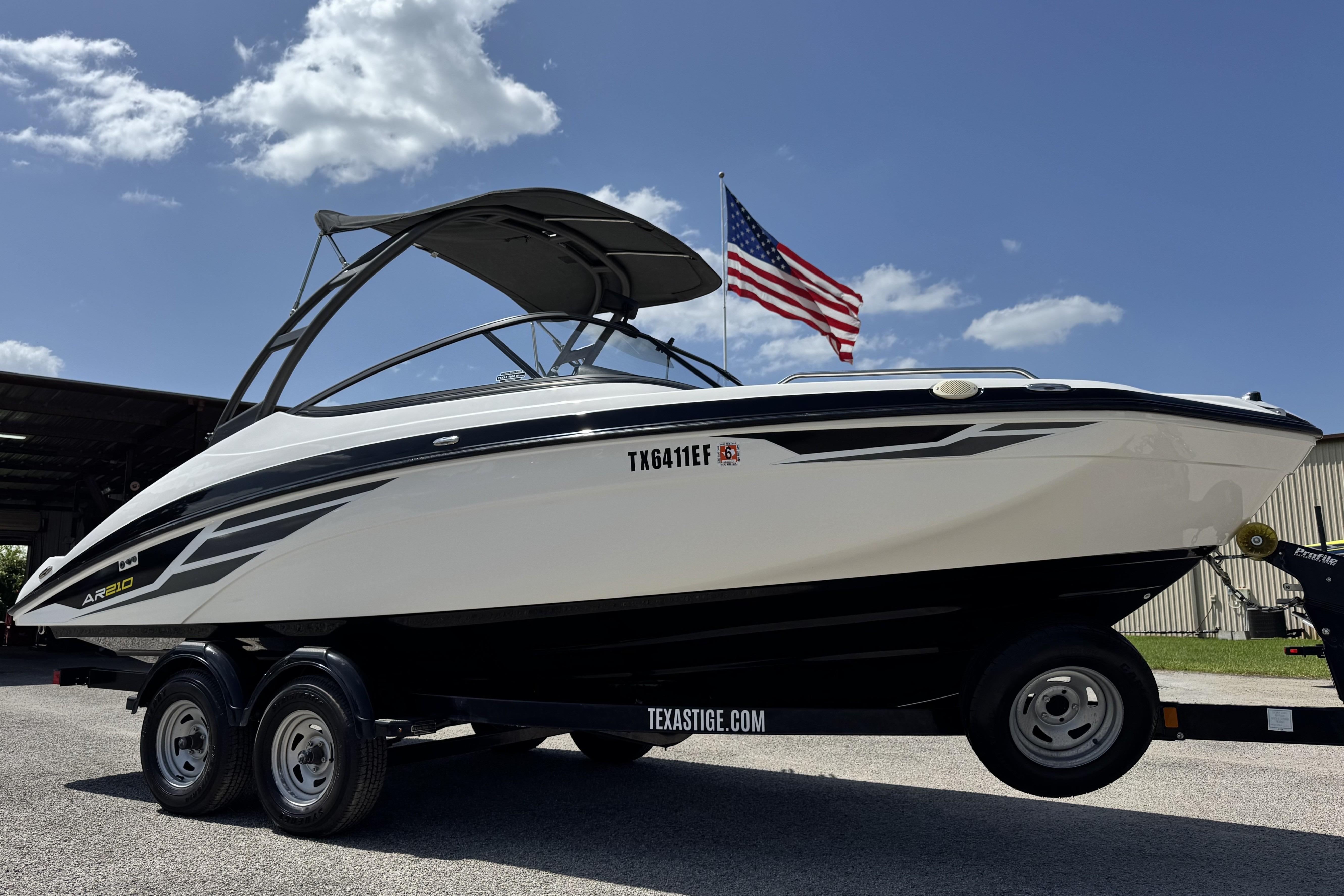 2018 Yamaha AR210 boat on trailer with American flag in background, under blue sky.