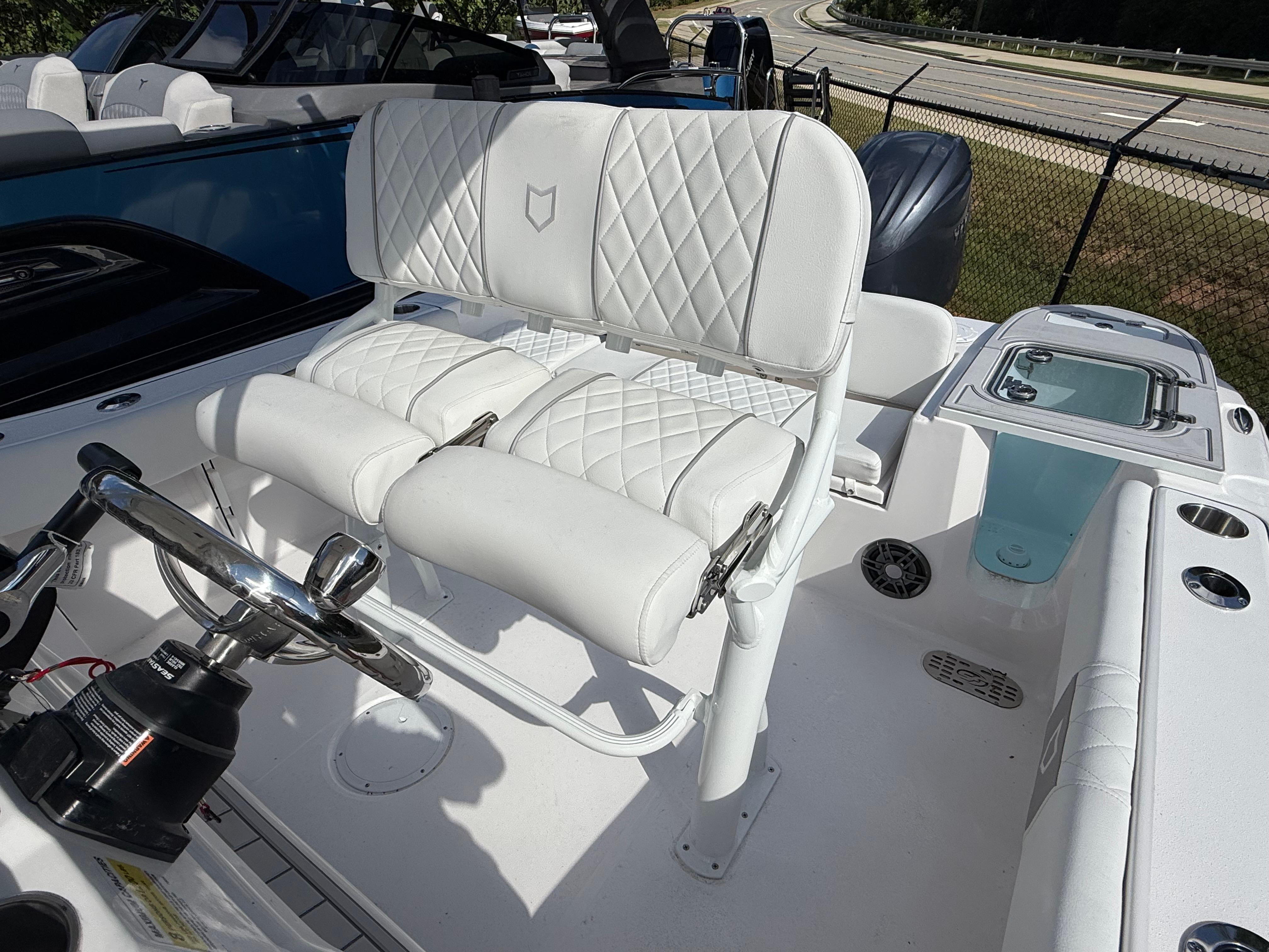 2026 Sea Fox 228 Commander boat interior with white cushioned seating and steering wheel.
