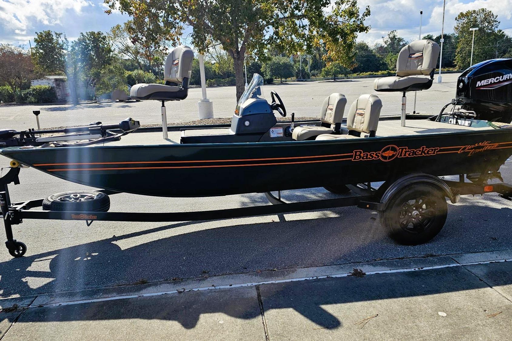 2026 Tracker Bass Tracker Classic Limited boat on trailer in sunny parking lot.
