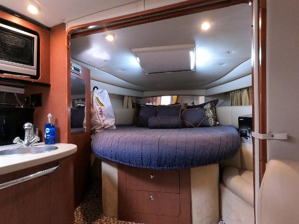 Interior of 2004 Chaparral Signature 350 yacht with cozy bed and kitchenette.